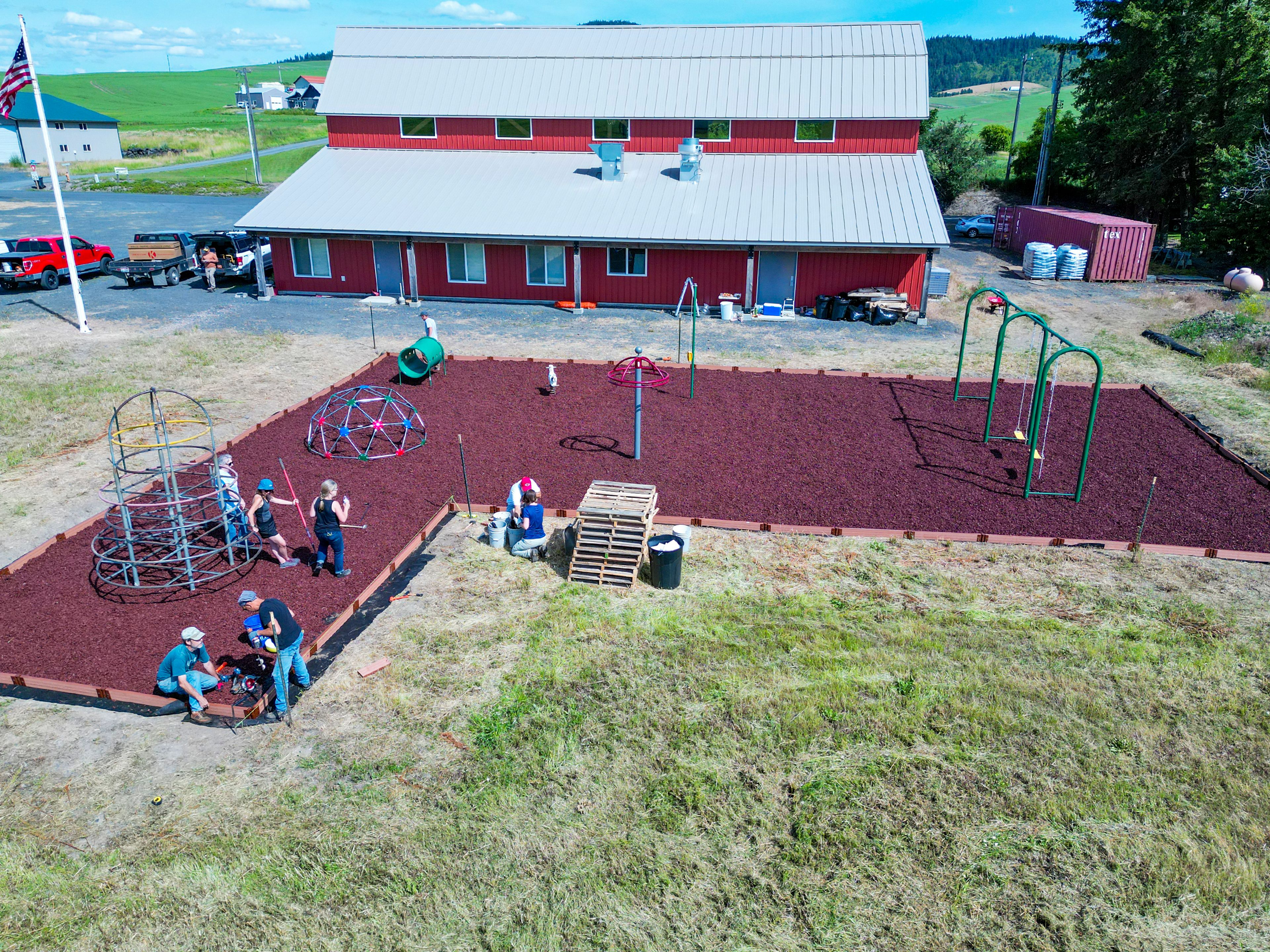 Viola community members work together to construct a playground outside of the Viola Community Center on Sunday, July 9, 2022.