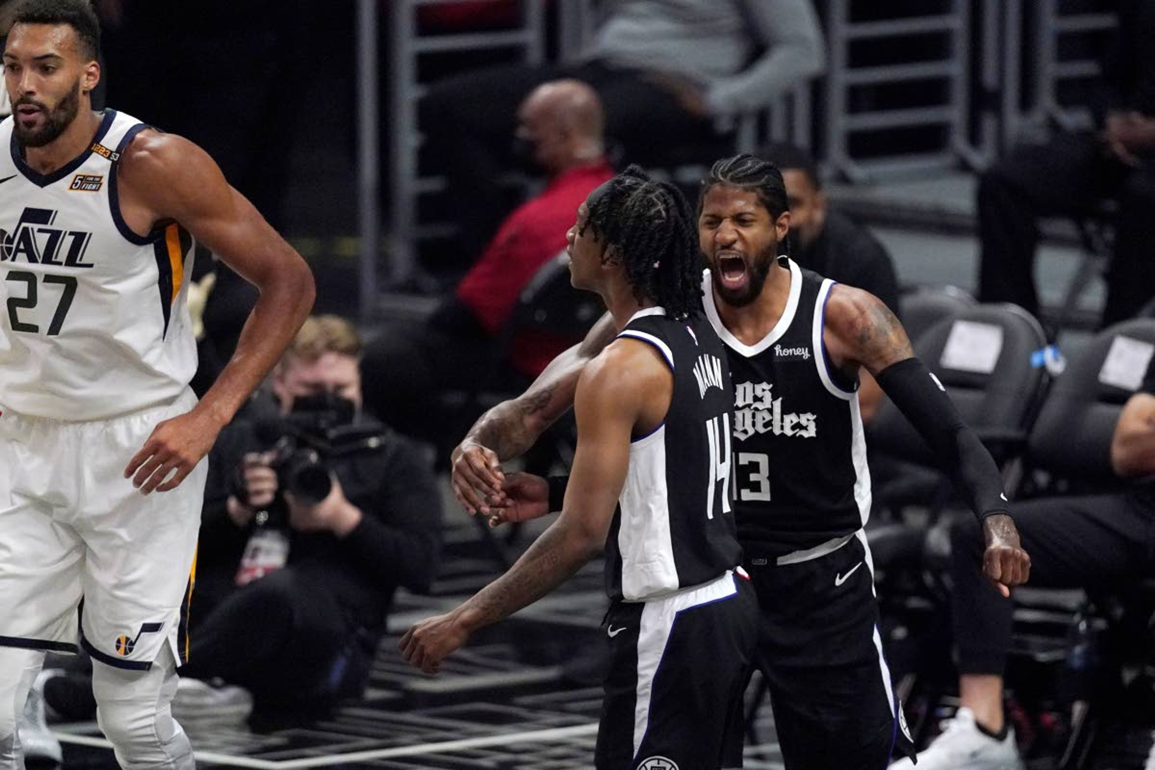 Los Angeles Clippers guard Terance Mann, center, celebrates with guard Paul George, right, after scoring and drawing a foul as Utah Jazz center Rudy Gobert stands by during the first half in Game 6 of a second-round NBA basketball playoff series Friday, June 18, 2021, in Los Angeles. (AP Photo/Mark J. Terrill)