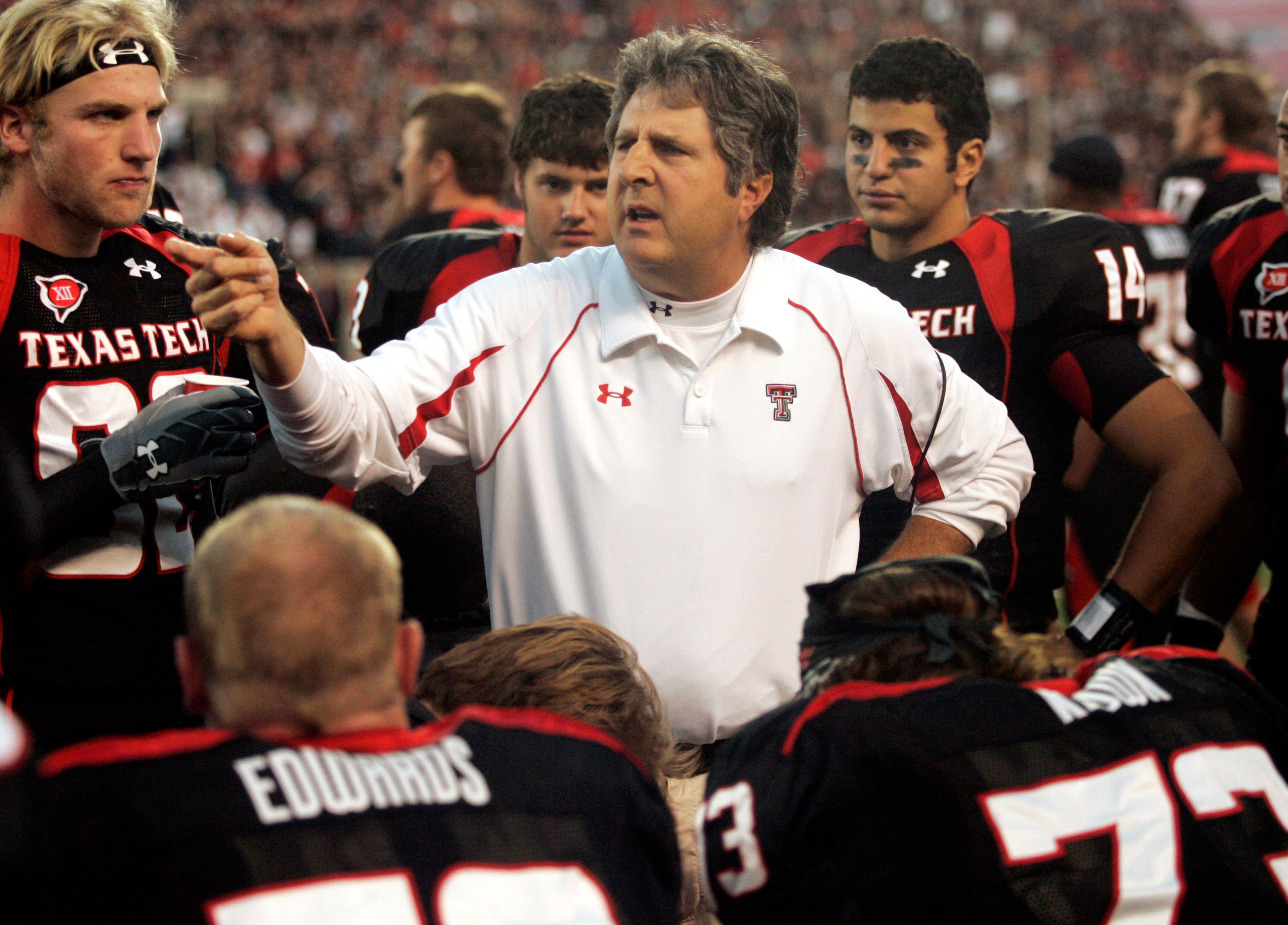 FILE - Texas Tech head coach Mike Leach talks with his team in the second quarter of an NCAA college football game against Texas A&M in Lubbock, Texas, Saturday, Oct. 24, 2009. Mike Leach, the gruff, pioneering and unfiltered college football coach who helped revolutionize the passing game with the Air Raid offense, has died following complications from a heart condition, Mississippi State said Tuesday, Dec. 13, 2022. He was 61. (AP Photo/Mike Fuentes, File)