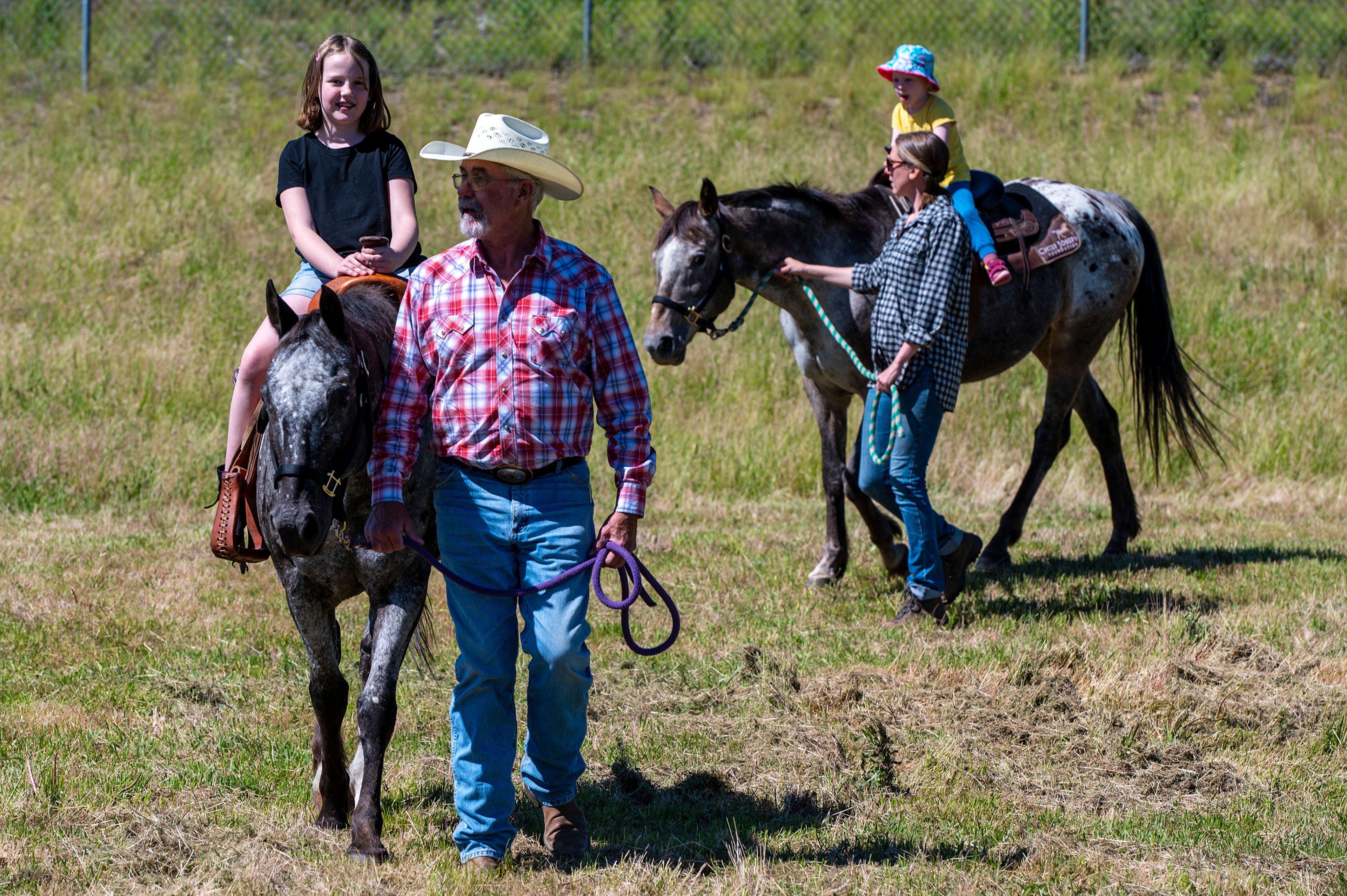 Zach Wilkinson/Daily News Mike Ewing, of the Chief Joseph Foundation, front, leads horse Happy and rider Anna Soderberg, 8, while board member Lauren McCleary leads horse Ruby and rider Rose Bromley-Vogel, 3, during the Appy Festival on Thursday at the Appaloosa Museum and Heritage Center in Moscow.