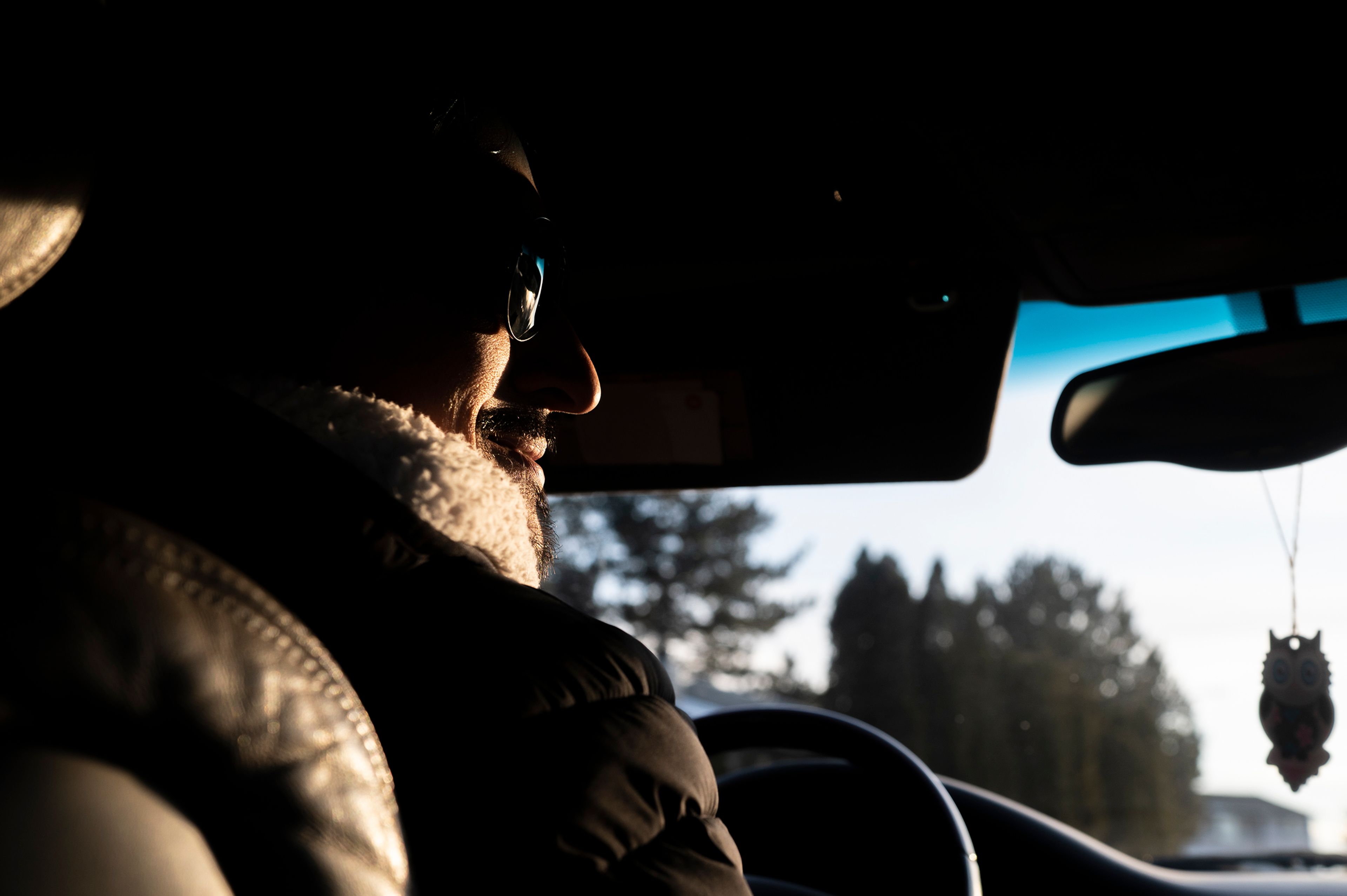 Sunlight illuminates the smile on Frank Contreras’ face while driving through Pullman delivering food. Contreras is seeking asylum in the U.S. and is not undocumented.