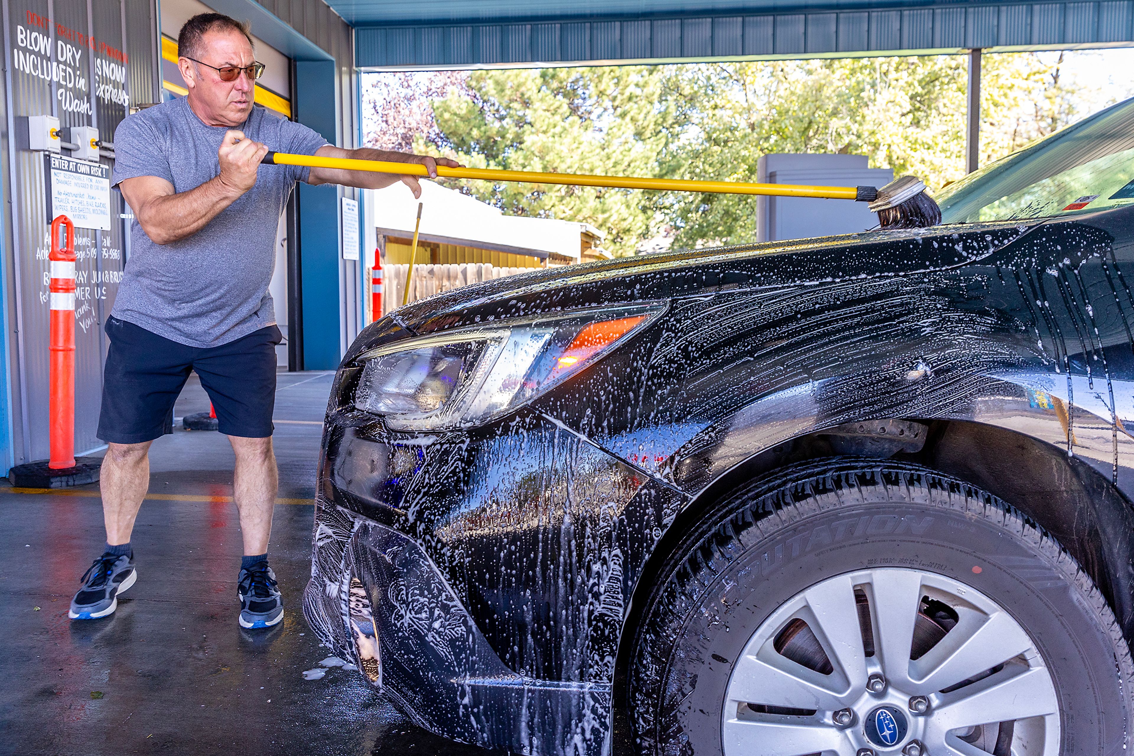 Jeff Port cleans the front of a car, including the insects squished on the front, at Adele�s Express Auto Wash in the Clarkston Heights.