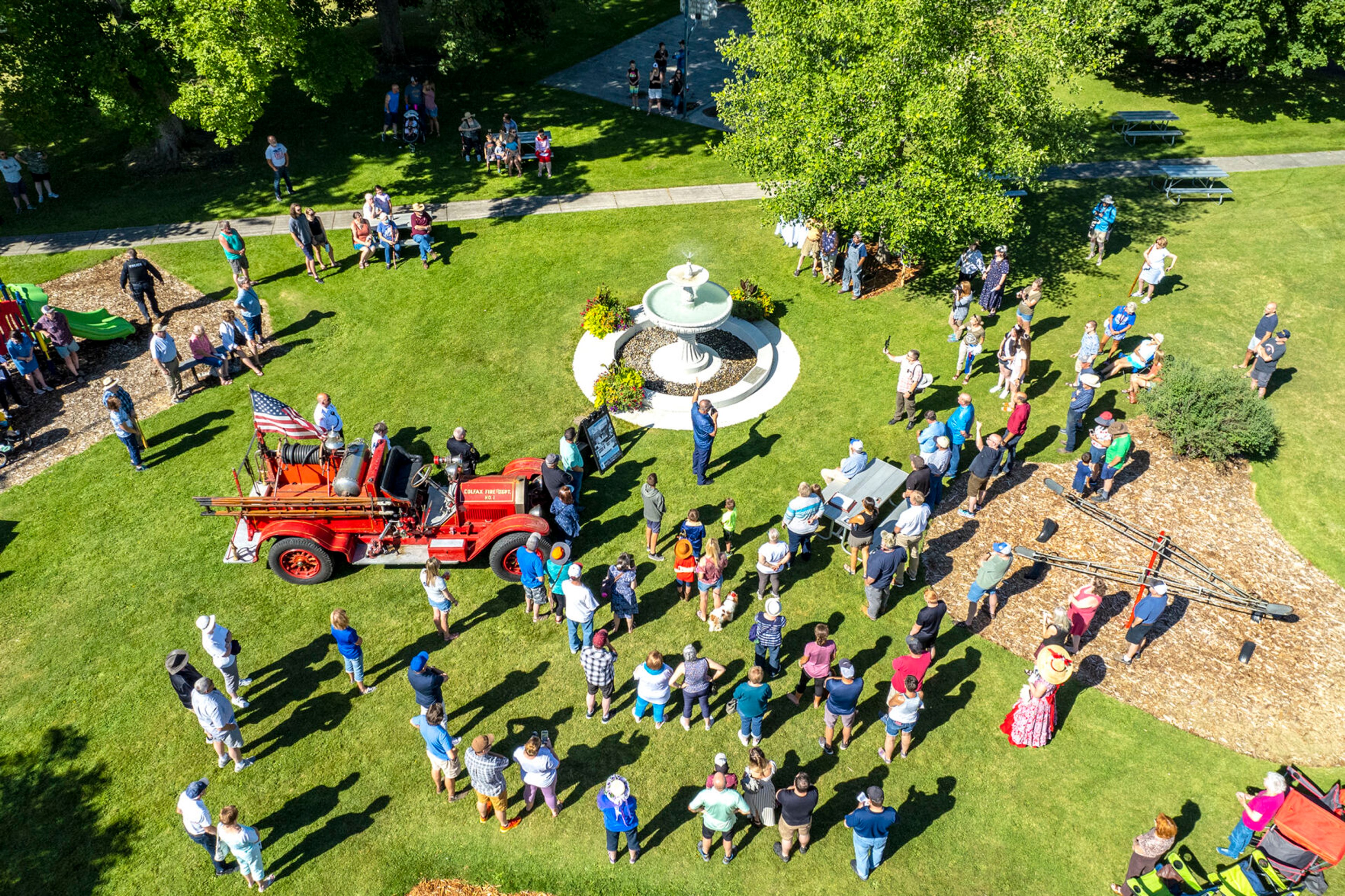 A photo captured with a drone on Saturday shows people gathering around the newly rededicated Lippett Fountain at Eells Park in Colfax during the city’s 150th birthday celebration.