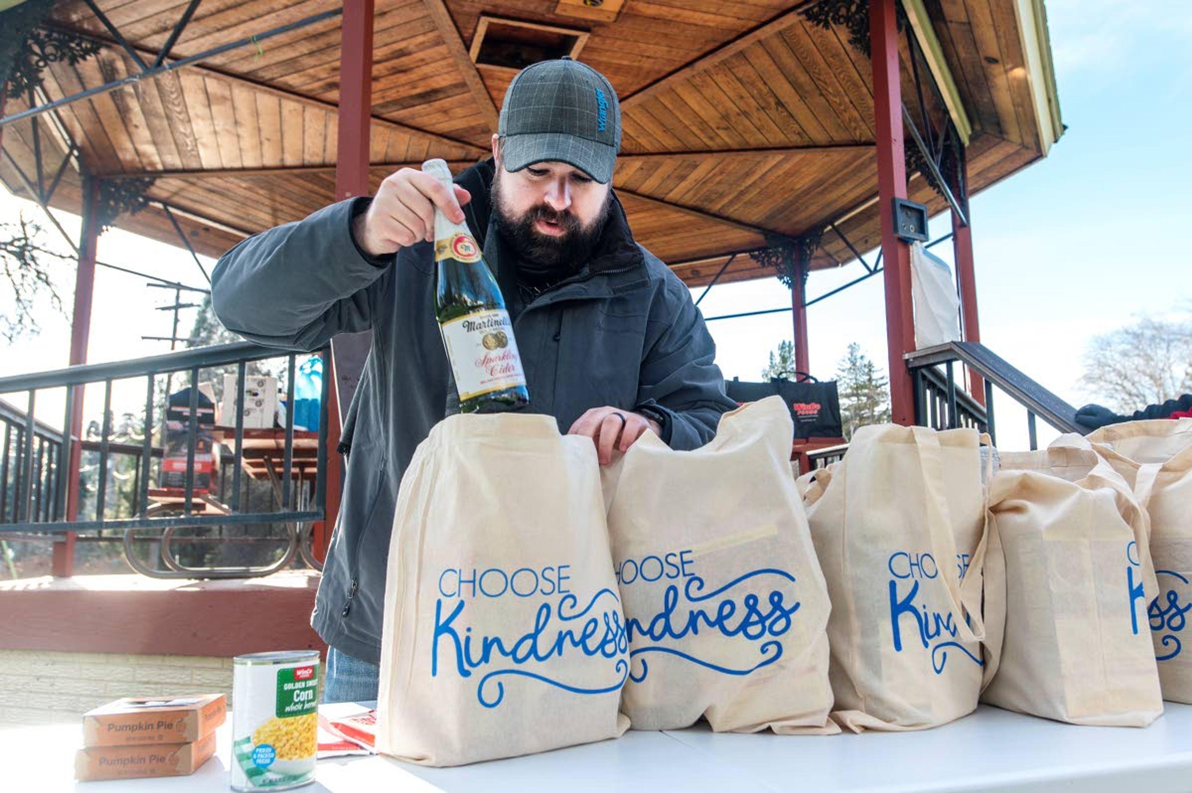 Rob Larsen, of Pullman, puts together bags of food containing typical Thanksgiving dishes Wednesday afternoon for a giveaway by the Food Security of the Palouse at Reaney Park in Pullman. Larsen acknowledged that many people have endured hardships over the last two years and said he wanted to give back to the community.