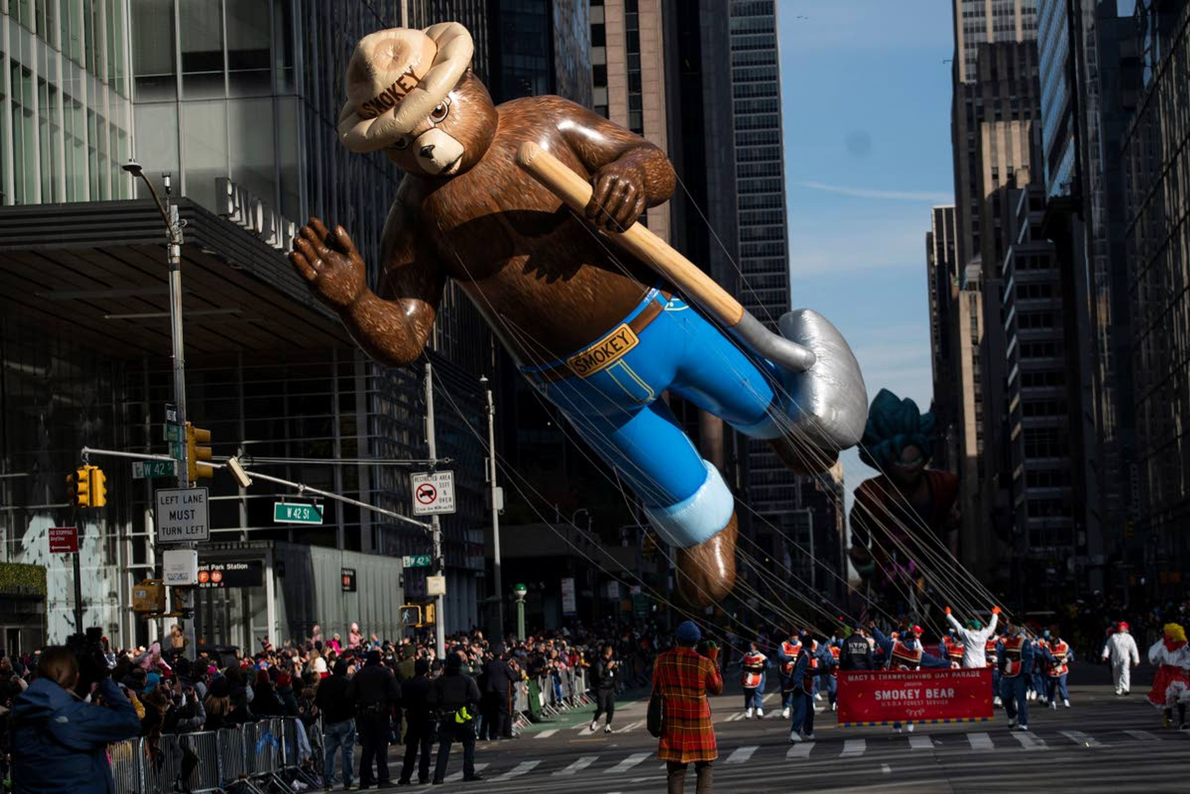 Balloon handlers pull Smokey the Bear through the intersection of Sixth Avenue and 42nd Street during the Macy's Thanksgiving Day Parade, Thursday, Nov. 25, 2021, in New York. (AP Photo/Eduardo Munoz Alvarez)