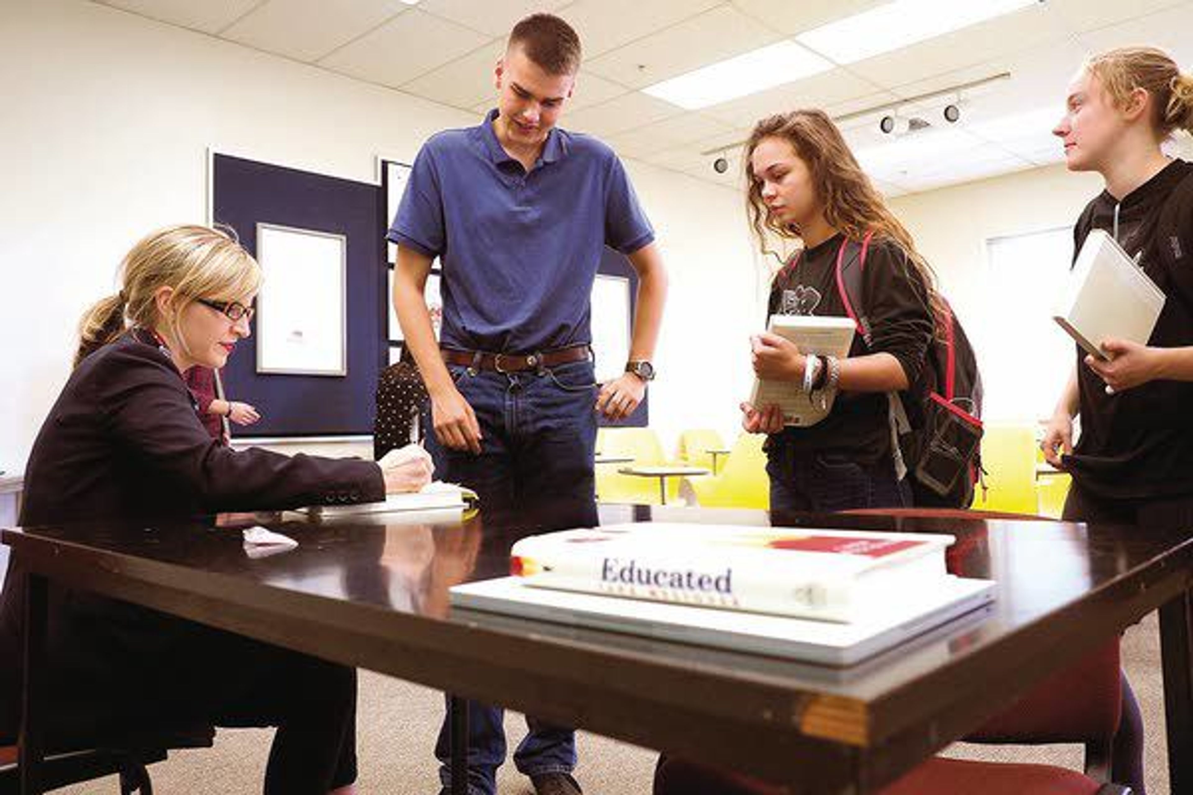 Tara Westover, left, signs a copy of her memoir, “Educated,” after speaking in Dave Harlan’s freshman seminar class, Everyone Has a Story, on Monday at the University of Idaho in Moscow.