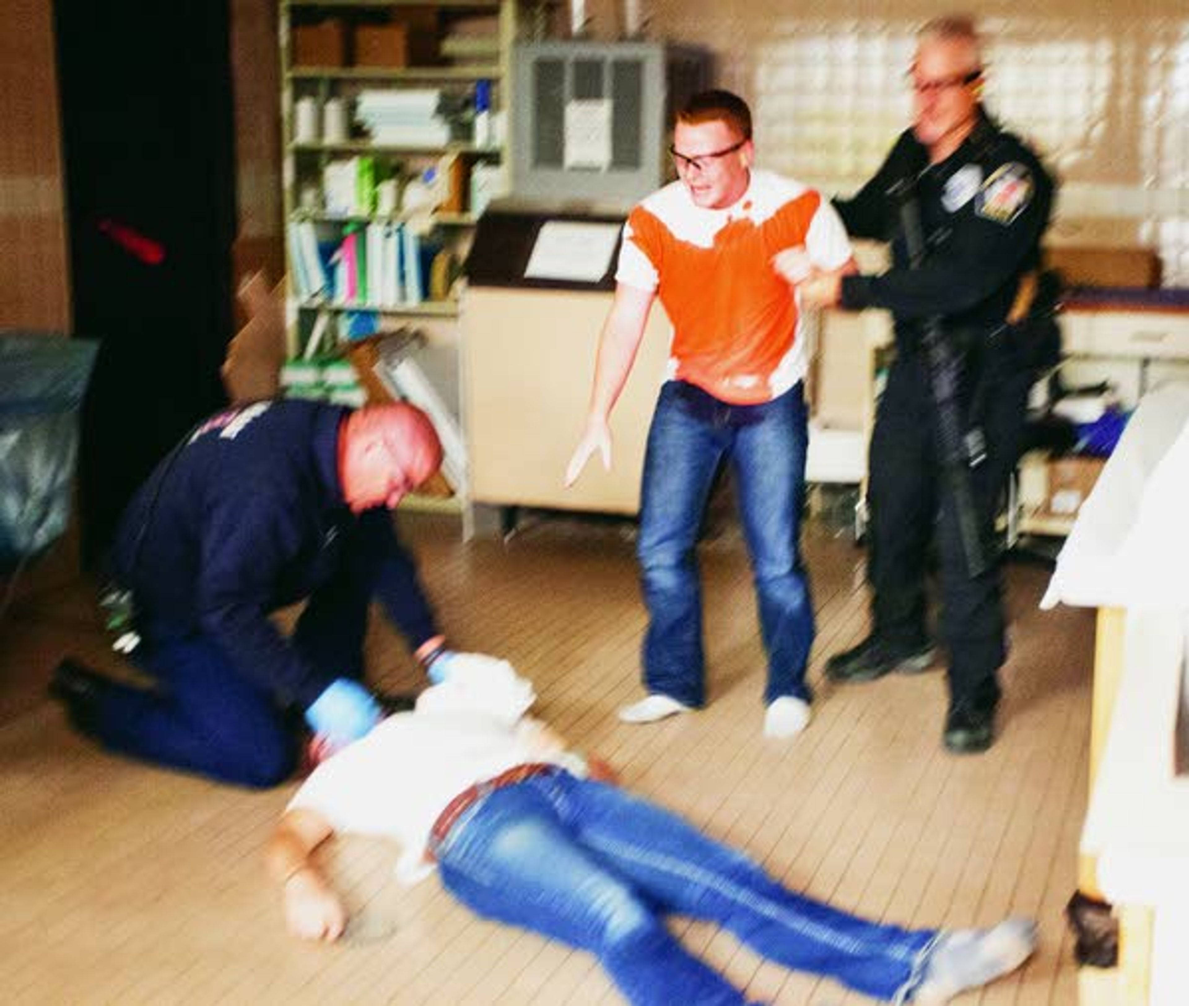 Washington State University police officer Jeff Olmstead, right, escorts a "grieving survivor" away from a "victim" suffering from a simulated wound to the left side of her neck as Pullman Fire Department medic Tony Nuttman triages her during an active shooter response drill run by the Pullman Police Department on Sunday at Summit Therapy in Pullman.