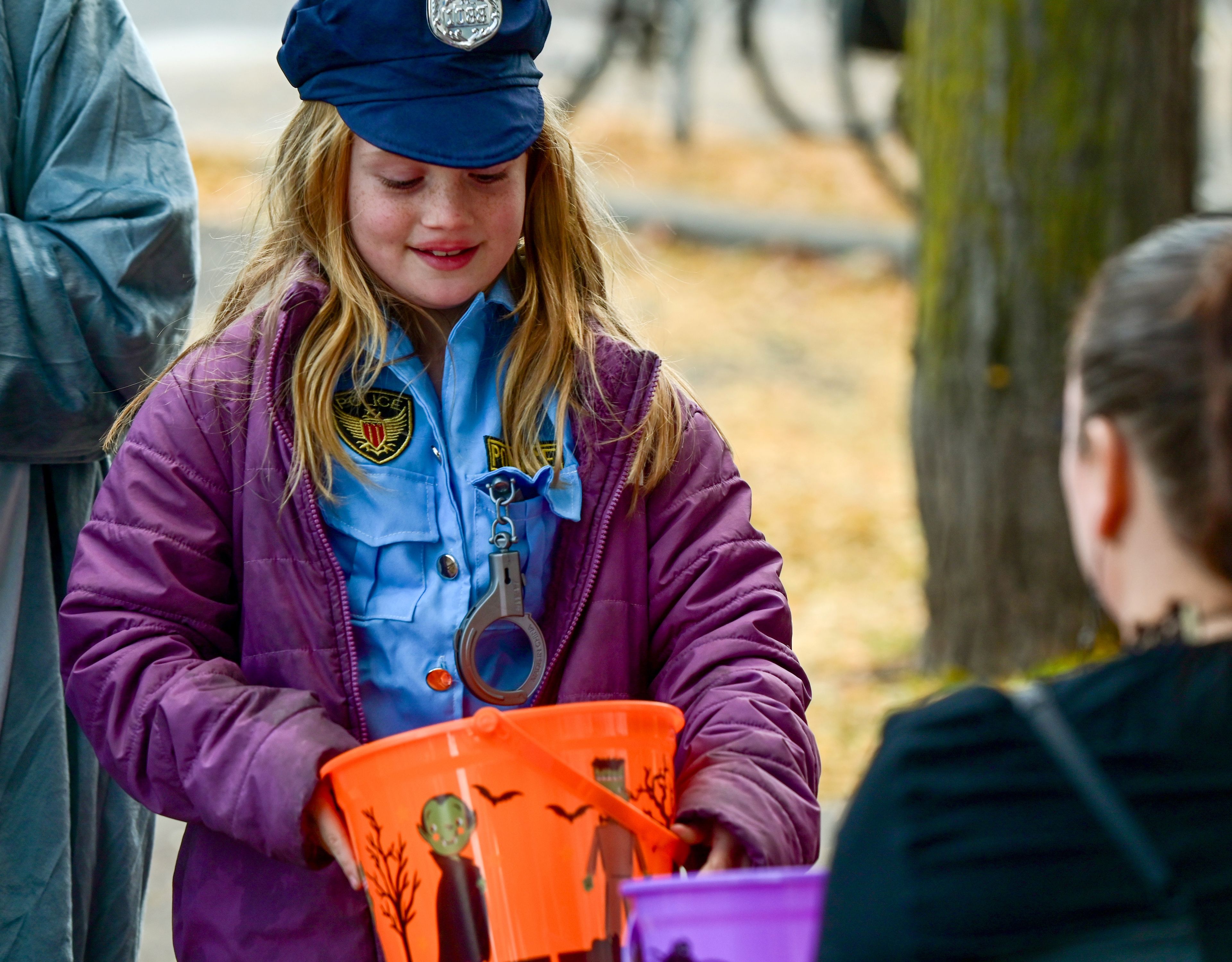 Blake Rouse, 7, smiles down at her bucket after receiving candy during Moscow’s Downtown Trick-or-Treat on Tuesday.