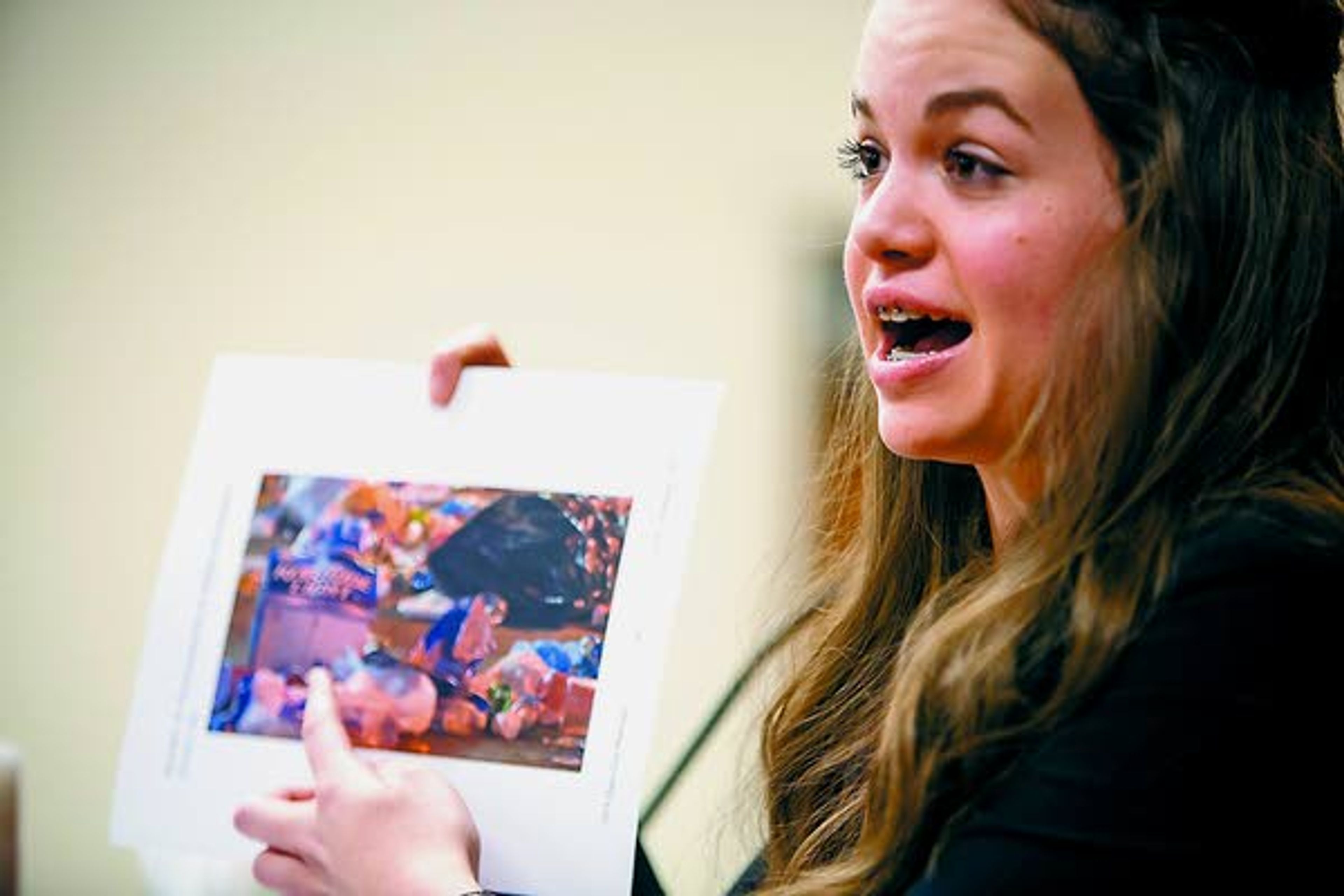 Current student Sofia Minudri, playing witness Tracey German (the former Twin Falls, Idaho, city manager), uses a photograph to highlight evidence during a Logos School mock trial team scrimmage against a group of mock trial alumni on Saturday, Feb. 22, 2014, at the Latah County Courthouse. Latah County prosecutor Bill Thompson acted as judge during the scrimmage.