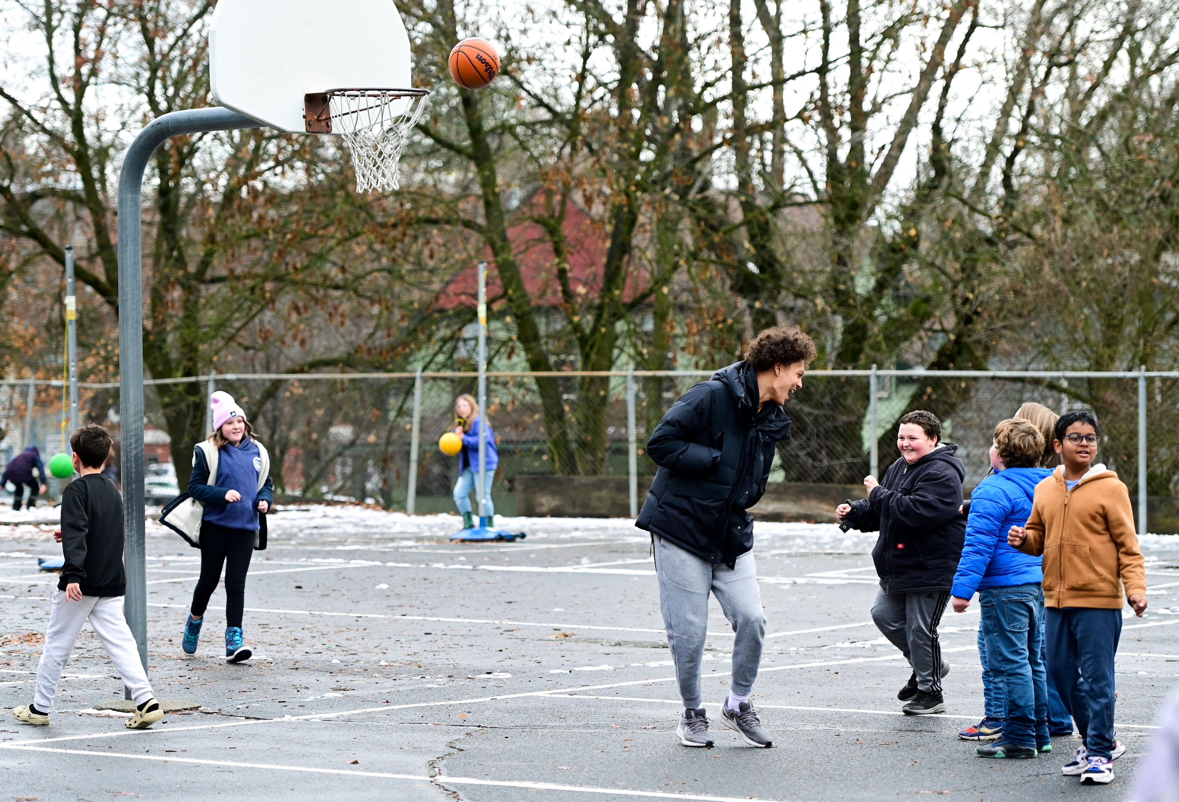 Idaho Vandal Trevon Blassingame, center, laughs with fifth graders under the net including Rize, center right, during recess at John Russell Elementary School in Moscow on Monday. The Vandals visit with students a few times each month during lunch and recess as mentors.