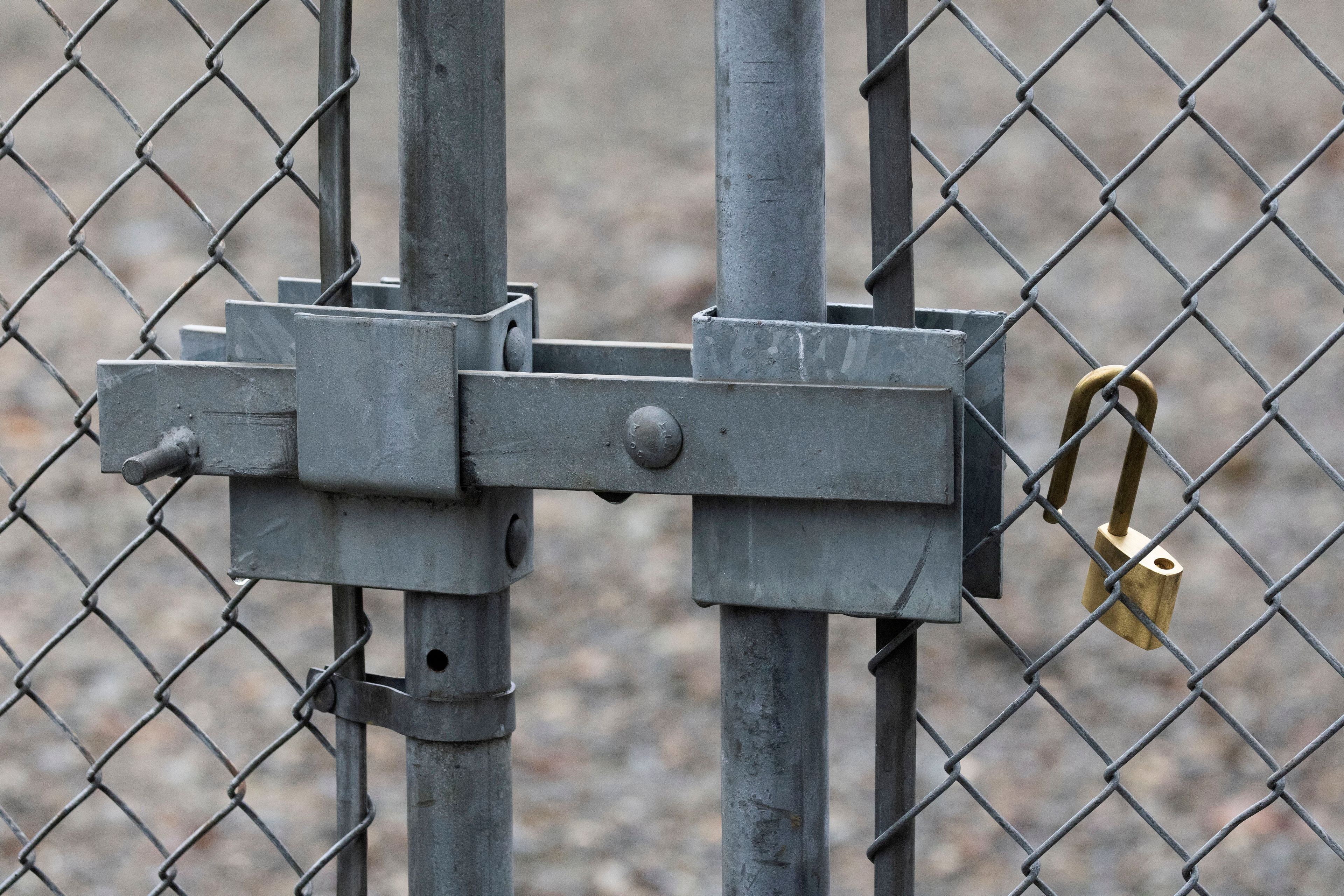 A Tacoma Power crew placed this new padlock at a substation gate after one that was cut off to break into the substation was taken away by law enforcement, Sunday, Dec. 25, 2022 in Graham, Wa. (Ken Lambert/The Seattle Times via AP)