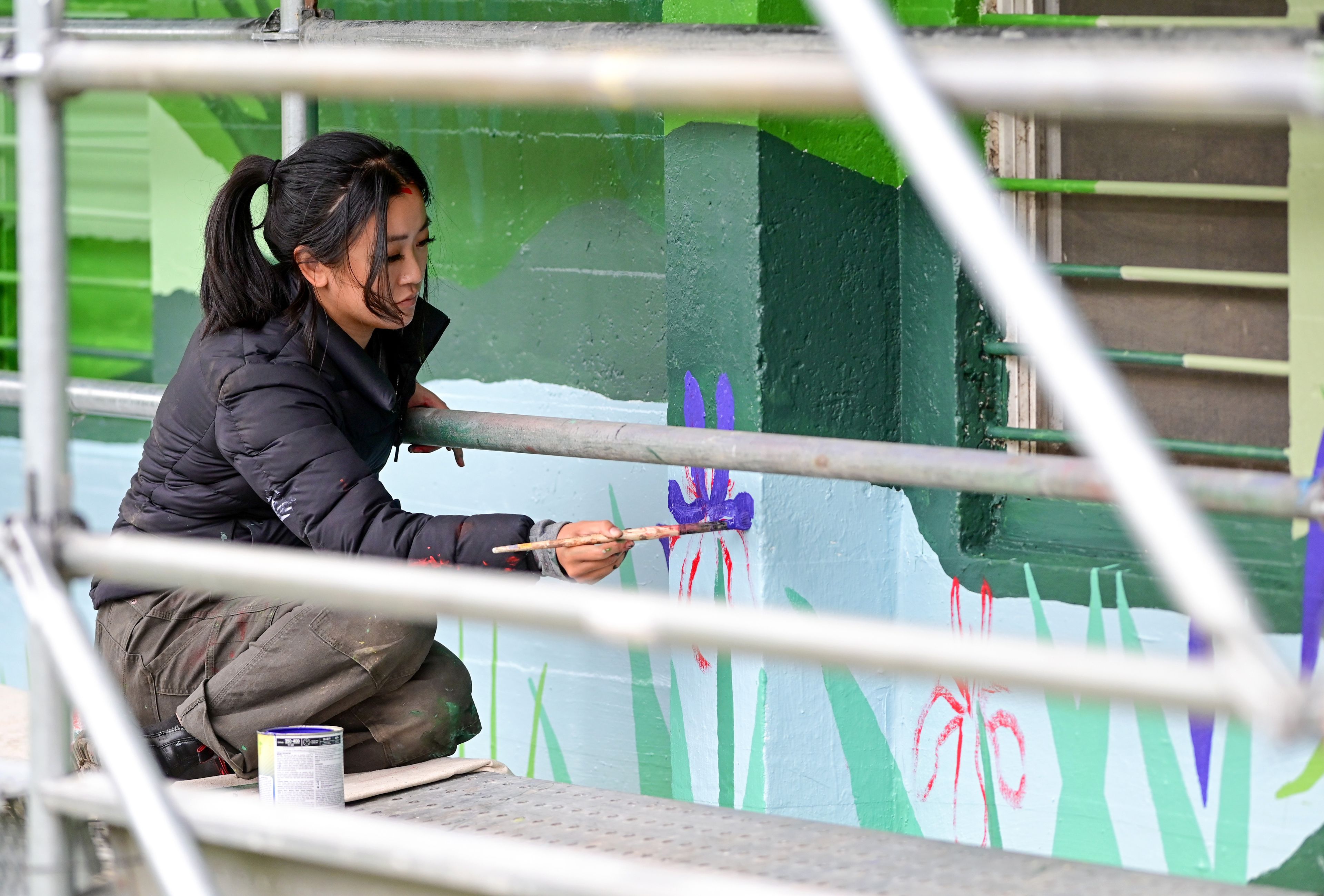 Tori Shao, an artist and landscape architect, works on a new mural in downtown Pullman.