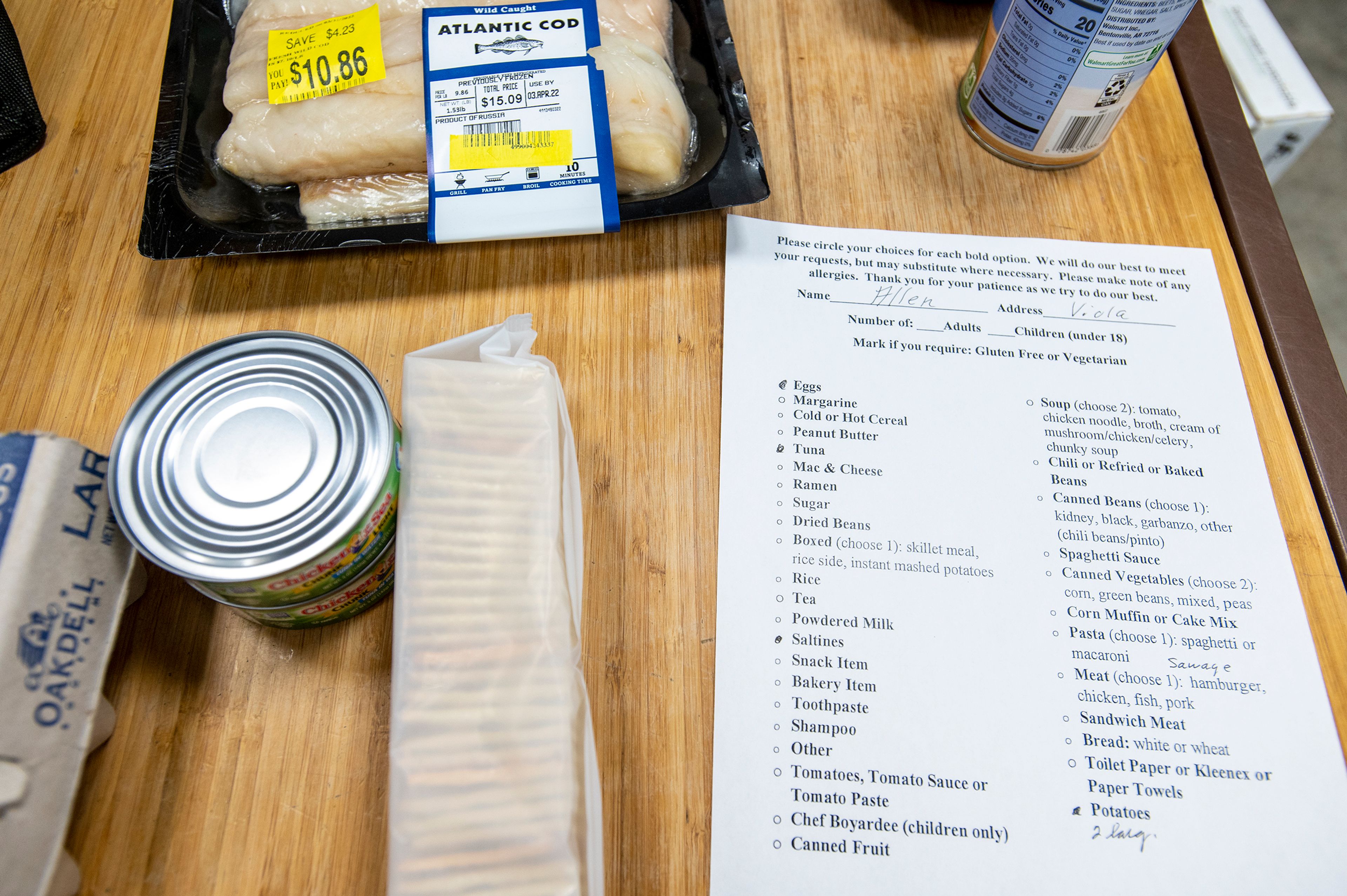 Grocery items are laid out on a table next to an order sheet as director Linda Nickels prepares a package Thursday afternoon at the Moscow Food Bank.