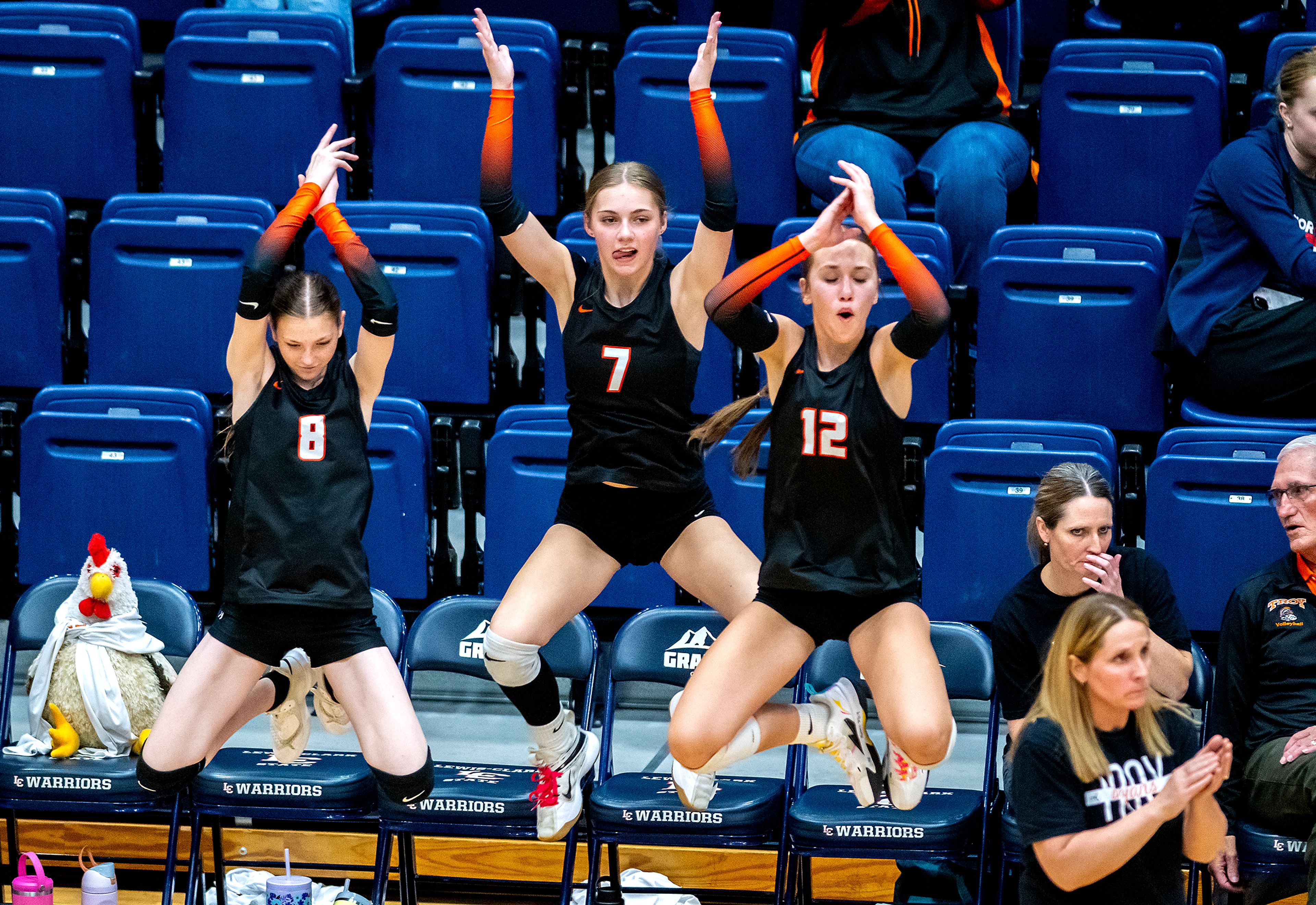 The Troy bench leaps into the air as the Trojans celebrate a point against Potlatch during a 2A district championship Wednesday at the P1FCU Activity Center in Lewiston.