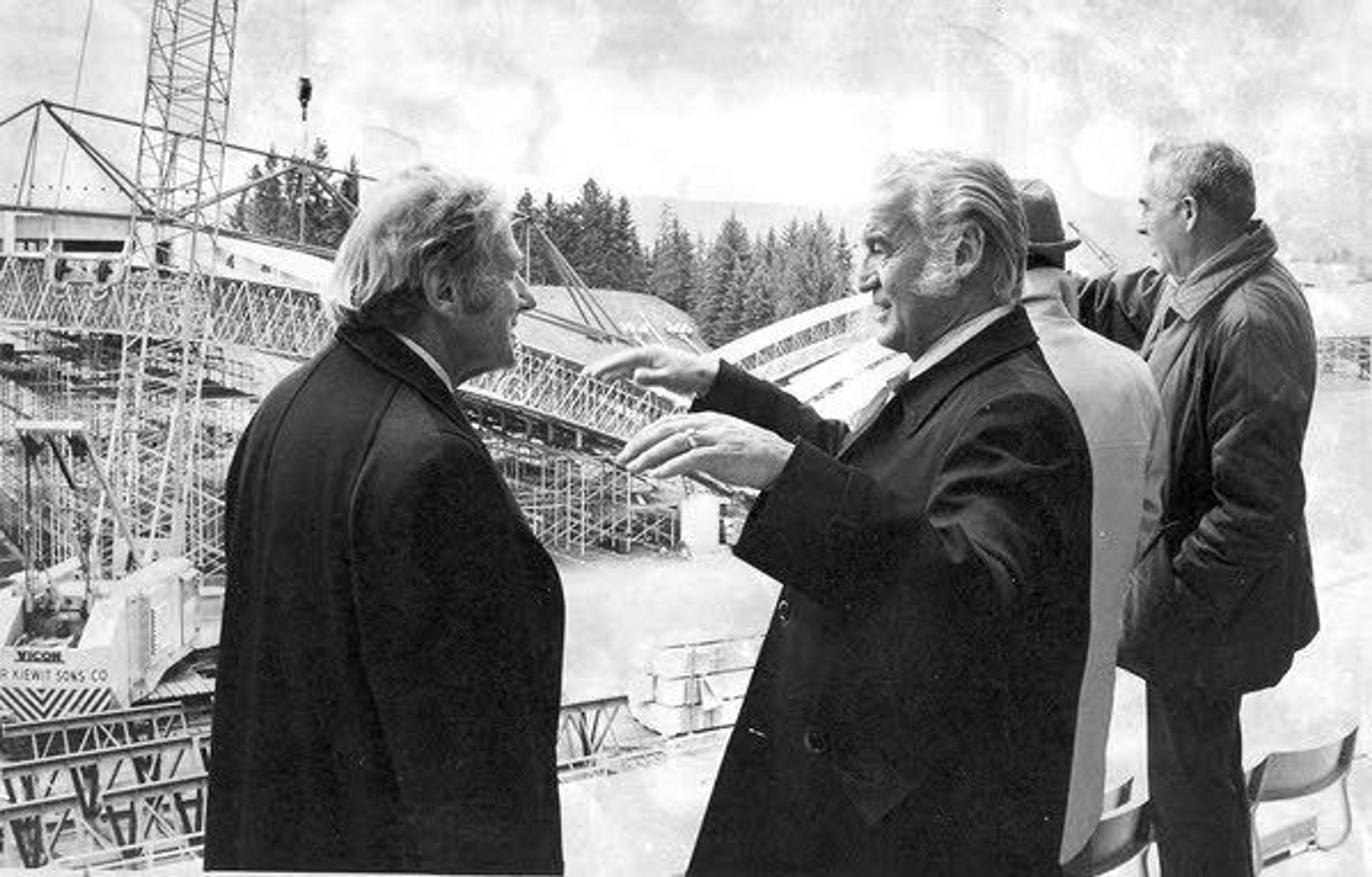 William Kibbie, center, talks with University of Idaho President Ernest Hartung, left, before the first roof beam is lifted into place on the ASUI-Kibbie Activity Center in Moscow in 1975.