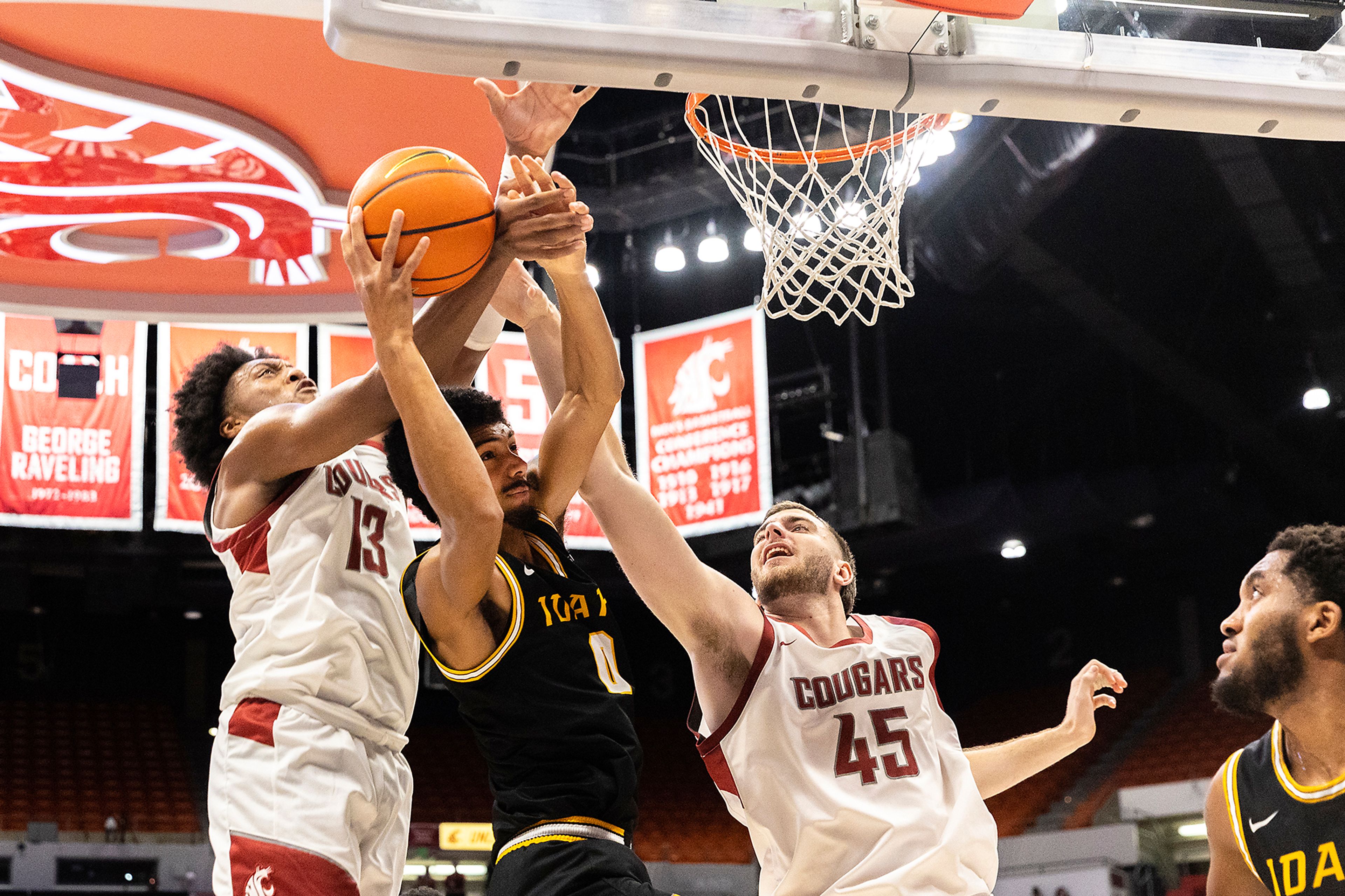 Washington State forwards Isaac Jones (13) and Oscar Cluff (45) go for a rebound over Idaho forward Julius Mims (0) during the Battle of the Palouse on Nov. 6 at Beasley Coliseum in Pullman.