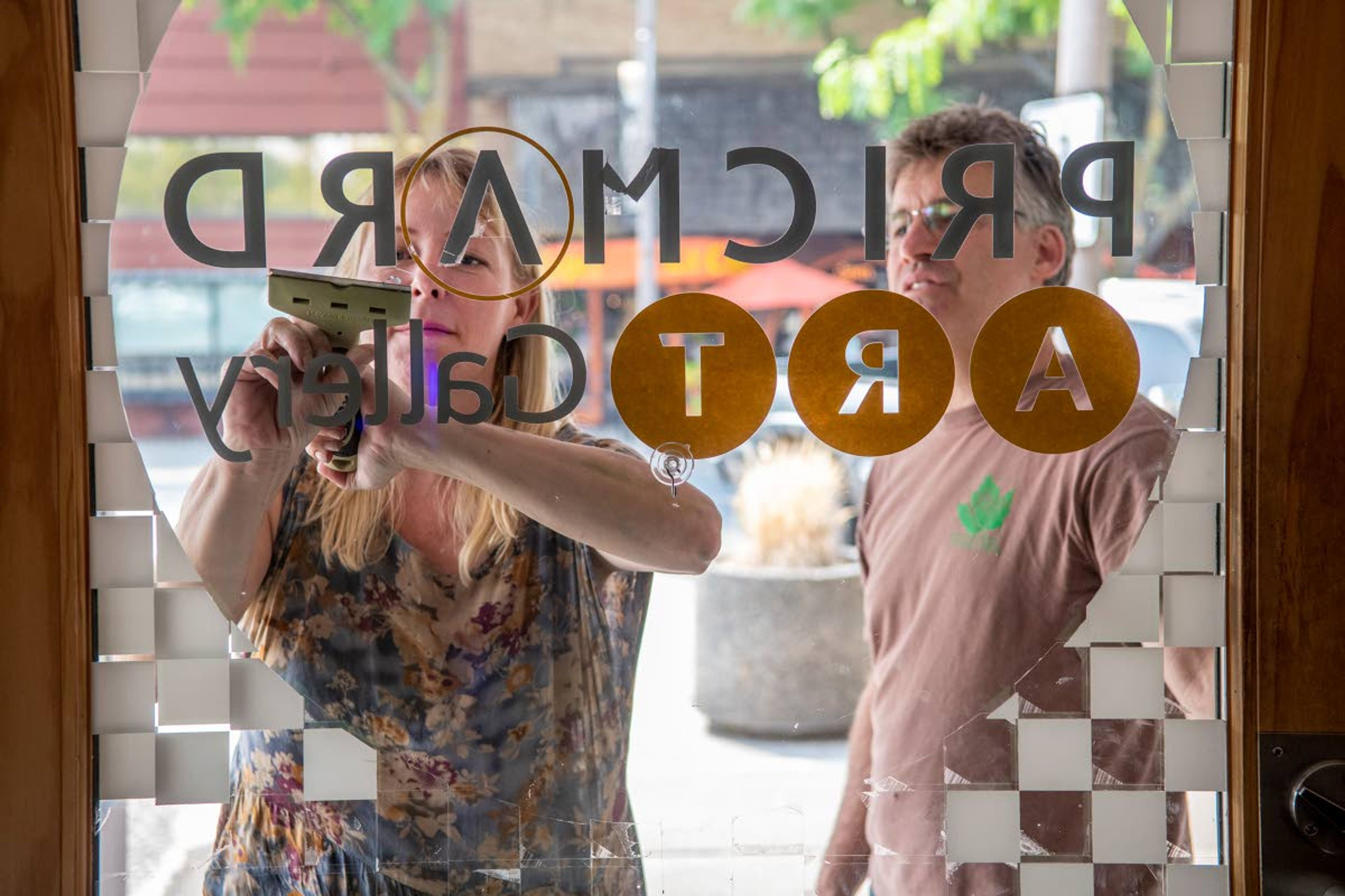 Foard, left, stands beside Rowley as she removes vinyl stickers from the door of the former Prichard Art Gallery in downtown Moscow on Wednesday afternoon.