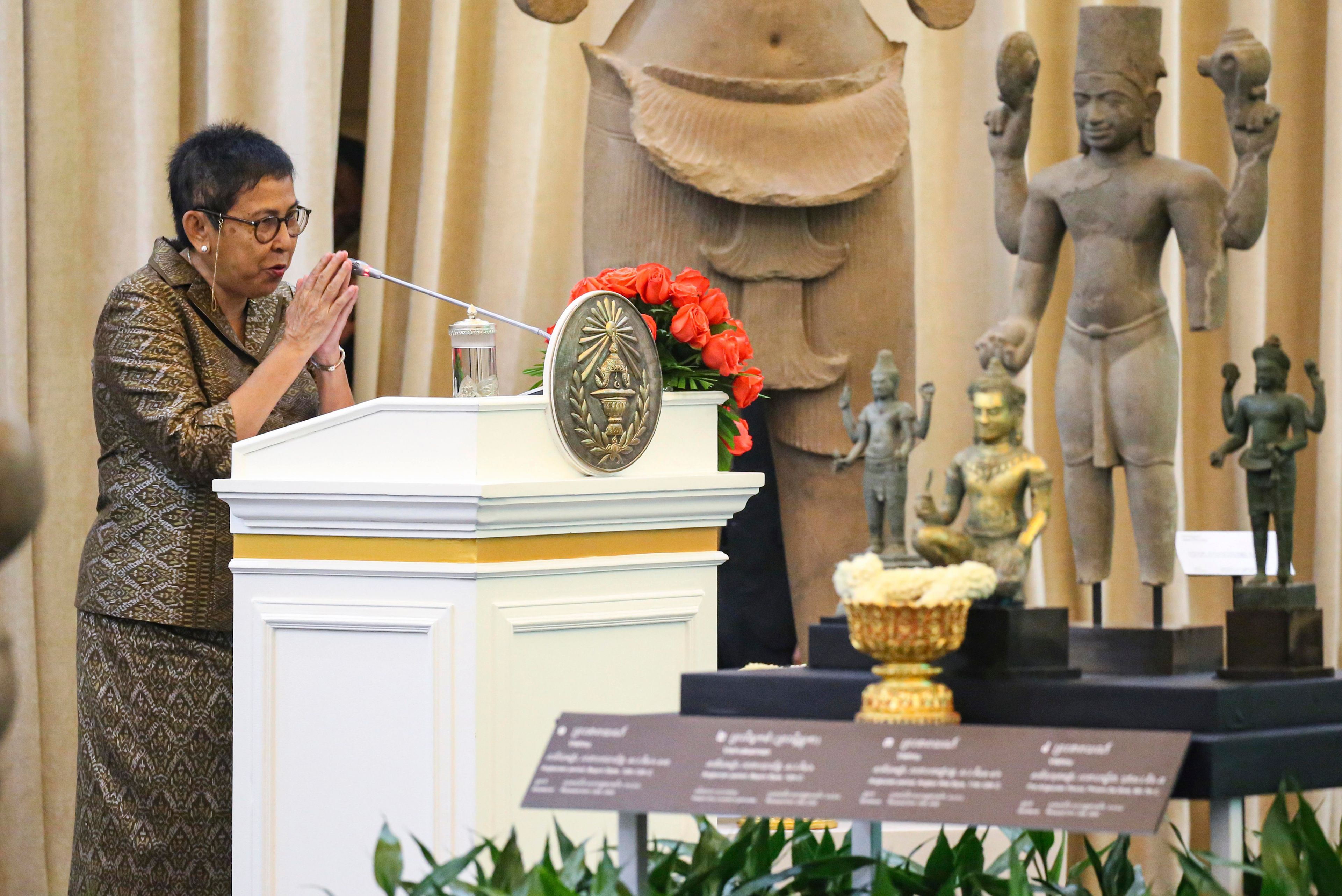 In this photo released by Agence Kampuchea Press (AKP), Cambodian Minister of Culture and Fine Arts Phoeurng Sackona greets before delivering a speech during a ceremony for the return of artifacts at Peace Palace in Phnom Penh, Cambodia, Thursday, Aug. 22, 2024. (AKP via AP)