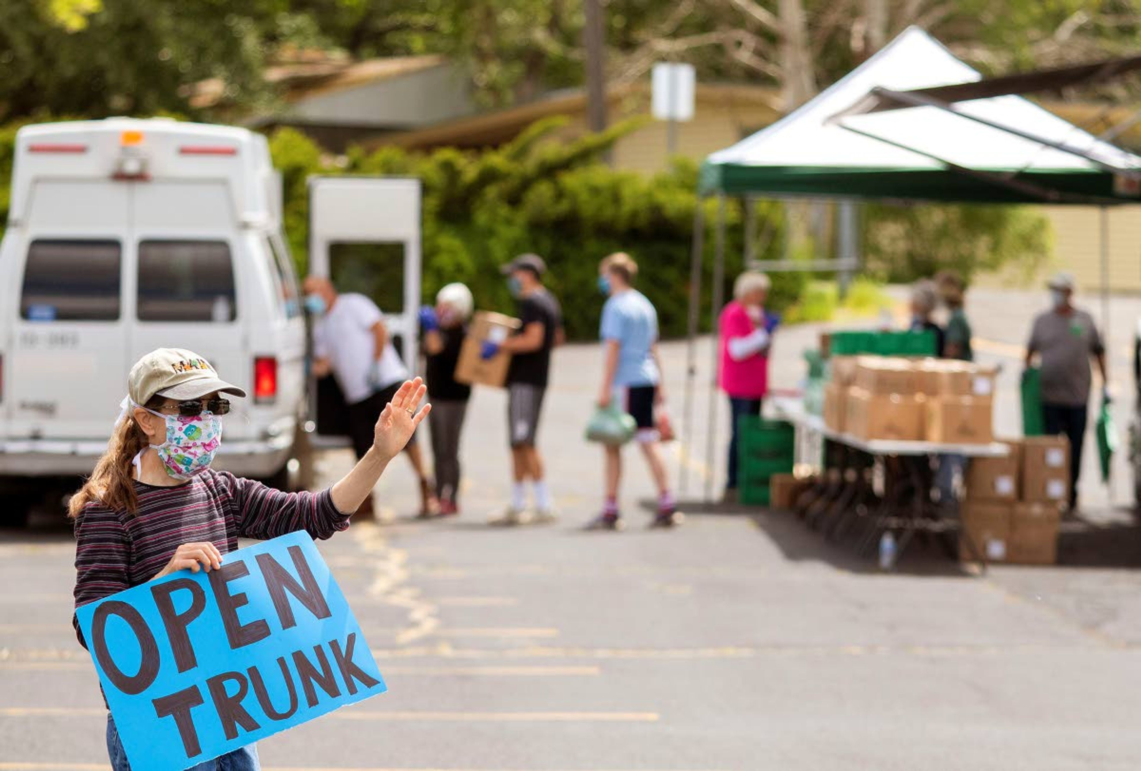 Volunteer Linda Fearn, left, directs motorists during a free food distribution Wednesday at Trinity Lutheran Church in Pullman. The event was organized by the church in cooperation with Second Harvest from Spokane.