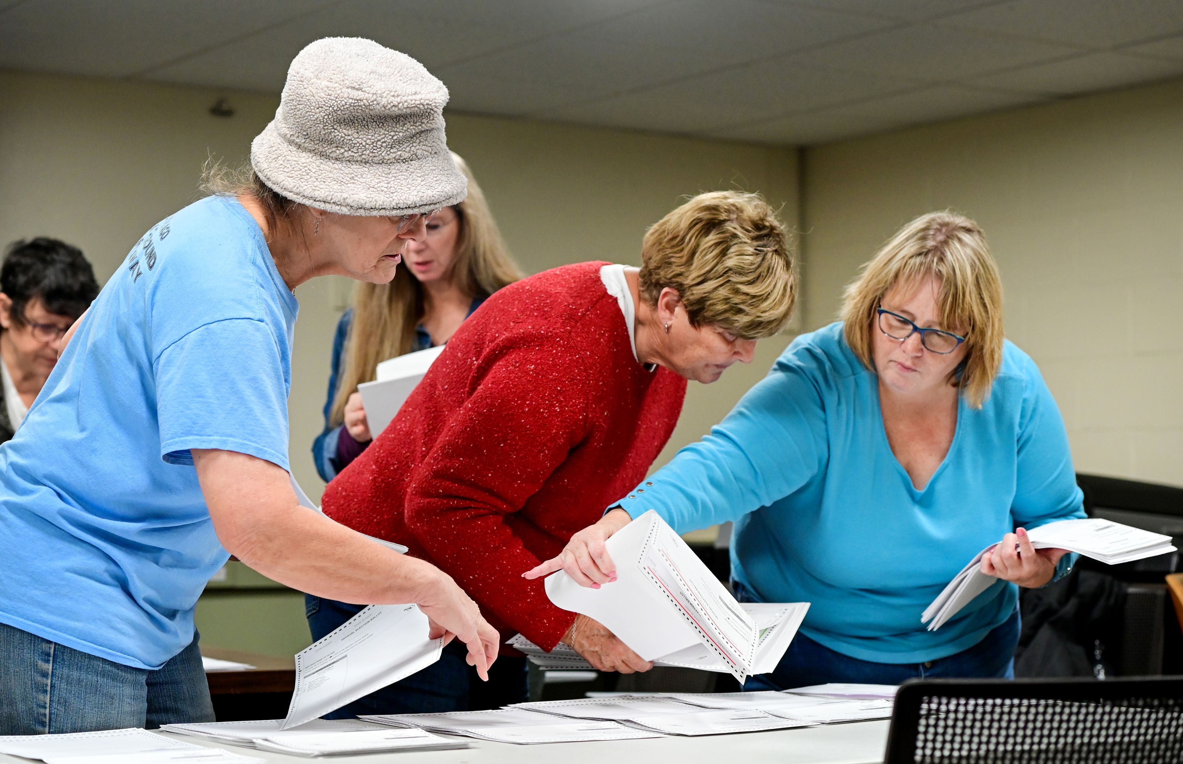 Karen Hansen, from left, Gail Schoenberg and Marci Mitchell organize absentee ballots before the start of a hand count for Latah County Elections in Moscow in the afternoon on Election Day.