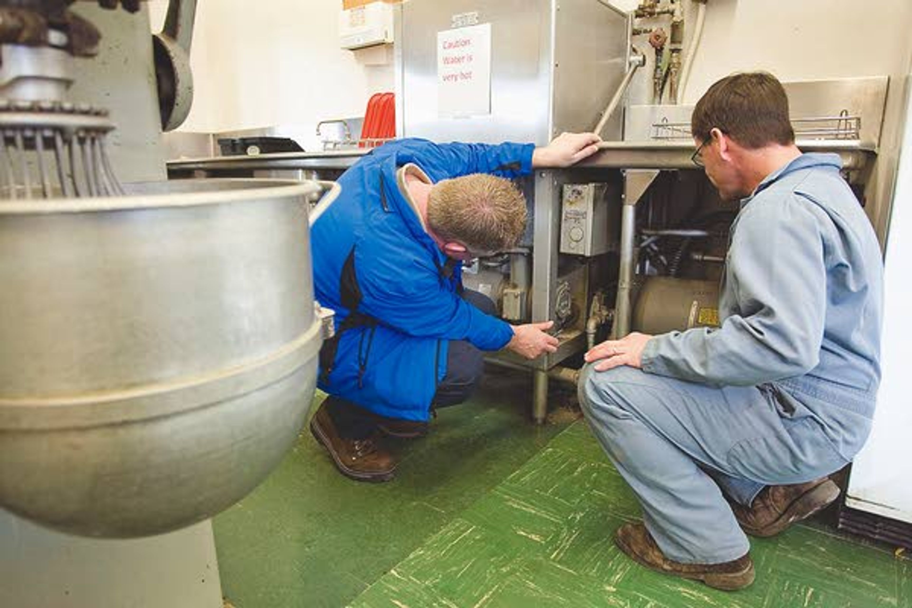 Colton School maintenance supervision Brad Nilson, right, talks to Dennis Kuntz from Blue Ribbon about a leaking dishwasher in the school's kitchen on Wednesday. The kitchen will be enlarged and remodeled if a $5.6 million bond passes.