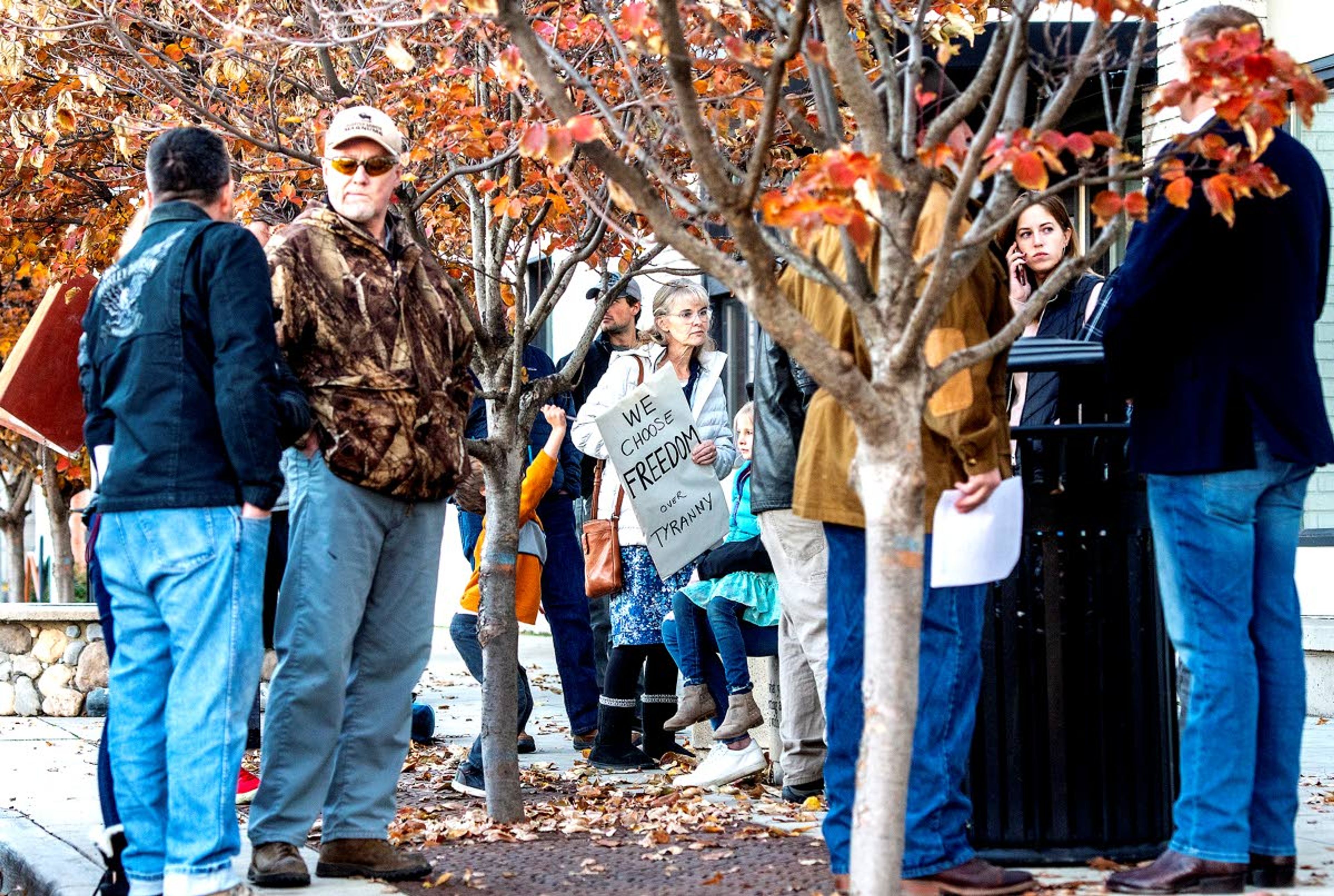 People stand outside the library as they await for space to become available inside where the Lewiston City Council was discussing a mask mandate Thursday afternoon.