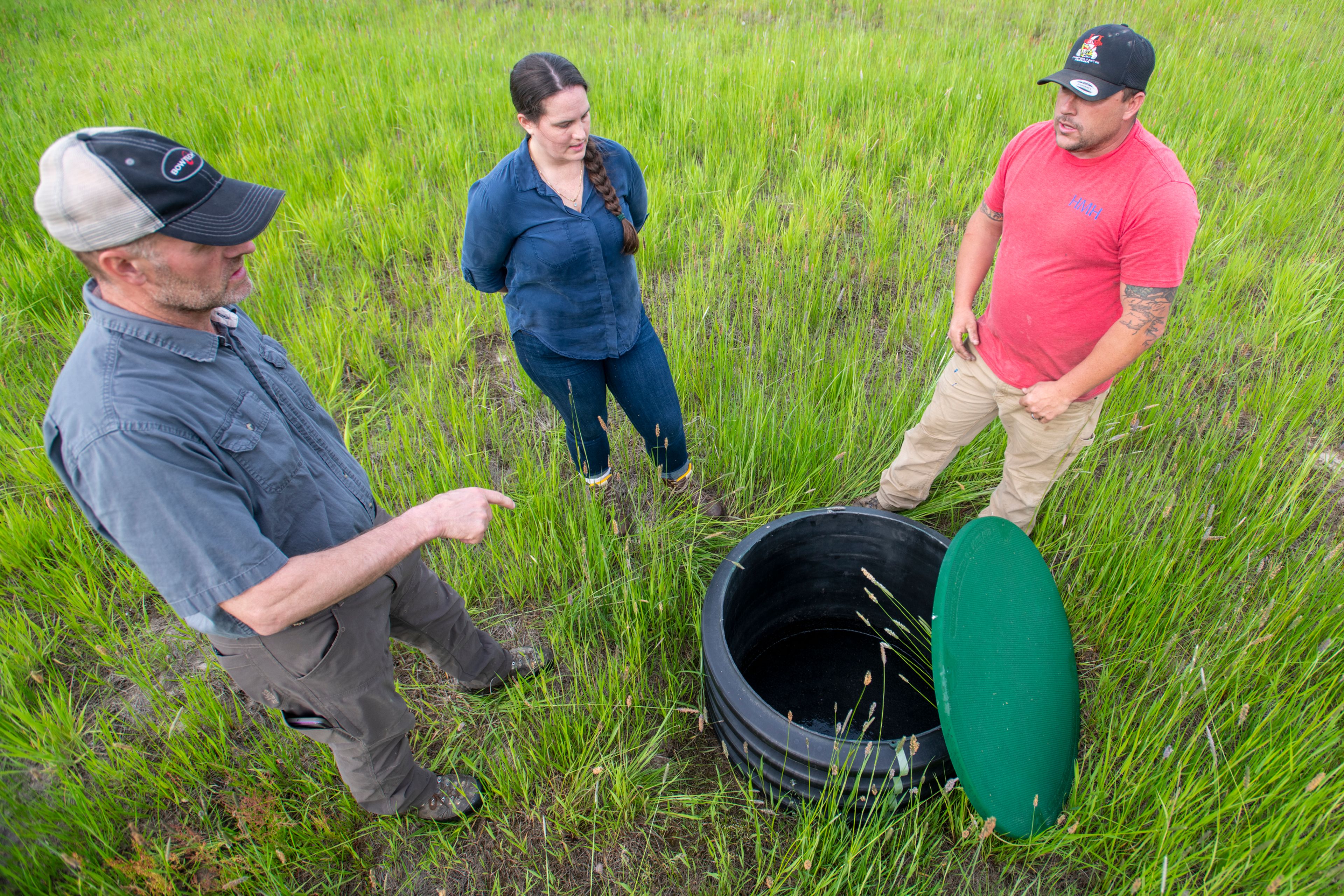 Zach Wilkinson/Daily News Hoodoo Water and Sewer District board member Kenny Merten, from left, DEQ compliance officer Jen Doughty and operator Leonard Johnson inspect a solenoid valve filled with water in Harvard’s sewage system Wednesday.