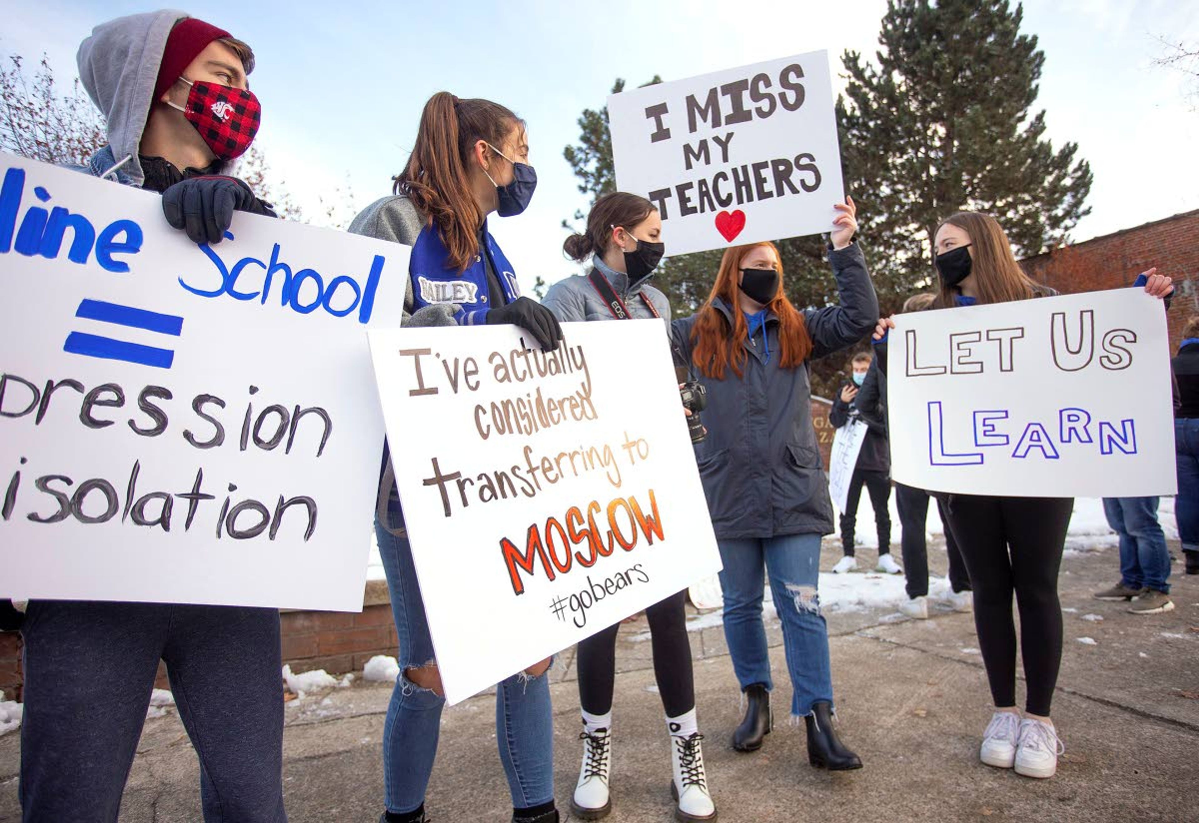 Pullman High School seniors Drew Hayton, left, and Hailey Talbot, second from left, participate in a demonstration urging the school board to transition to in-person classes.