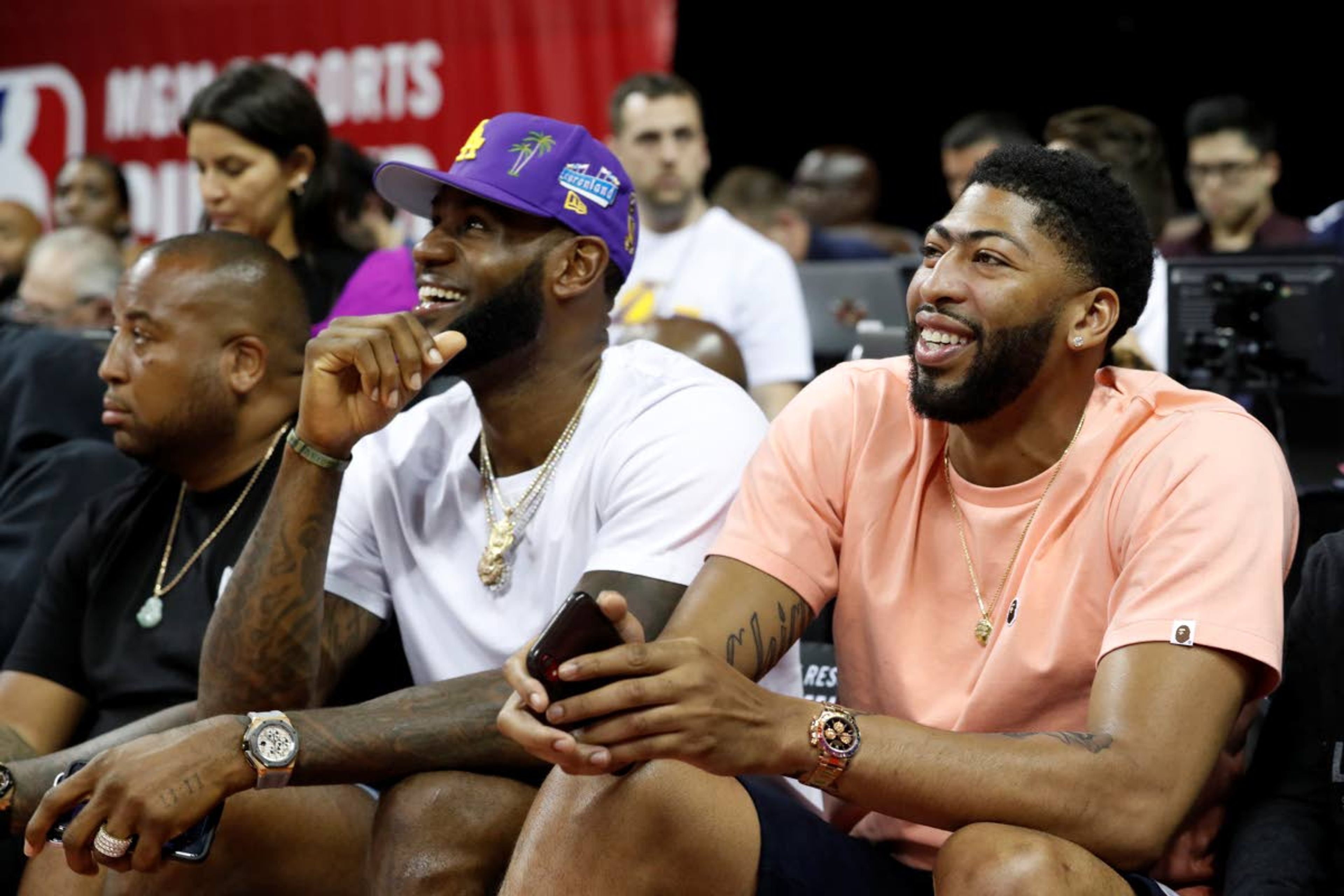 Los Angeles Laker players LeBron James, center, and Anthony Davis, right, take in an NBA summer league basketball game between the New York Knicks and the New Orleans Pelicans, Friday, July 5, 2019, in Las Vegas. (AP Photo/Steve Marcus)