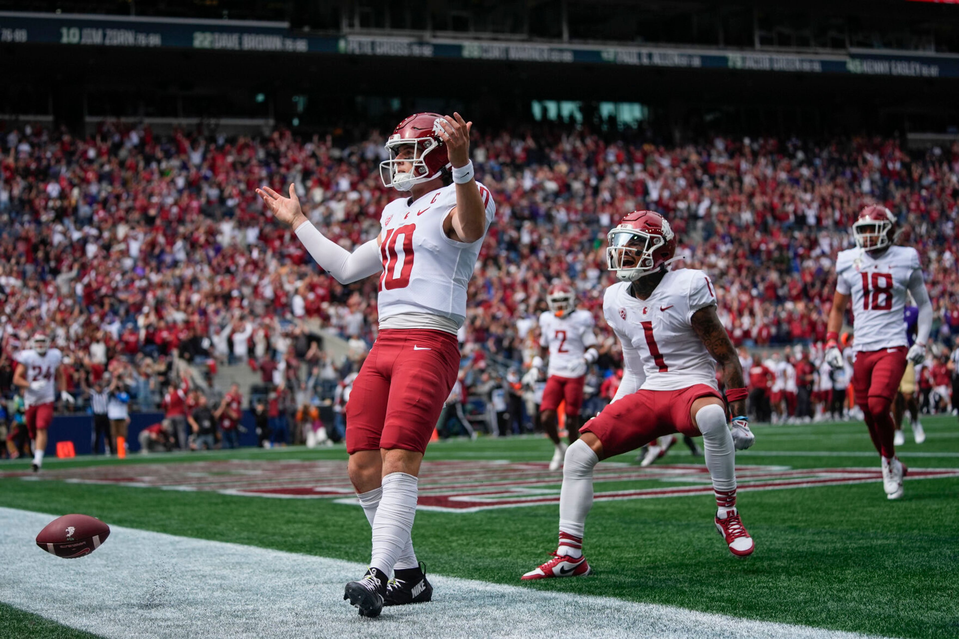 Washington State quarterback John Mateer reacts after running for a touchdown as wide receiver Kris Hutson (1) runs to greet him during the first half of an NCAA college football game against Washington, Saturday, Sept. 14, 2024, in Seattle. (AP Photo/Lindsey Wasson)