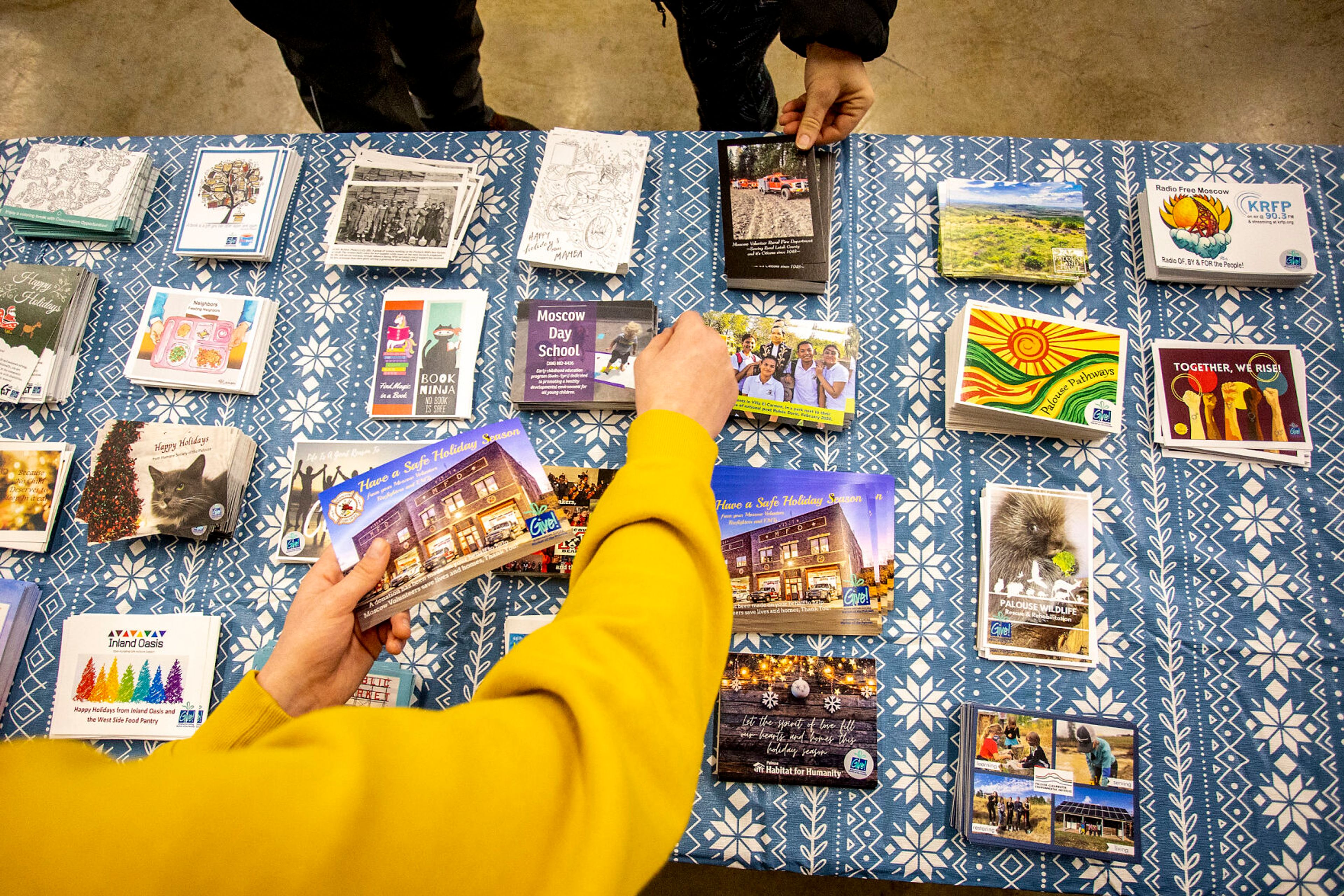 Post cards of the various non-profit organizations represented at the Alternative Giving Market sit out on a table in Moscow on Saturday.