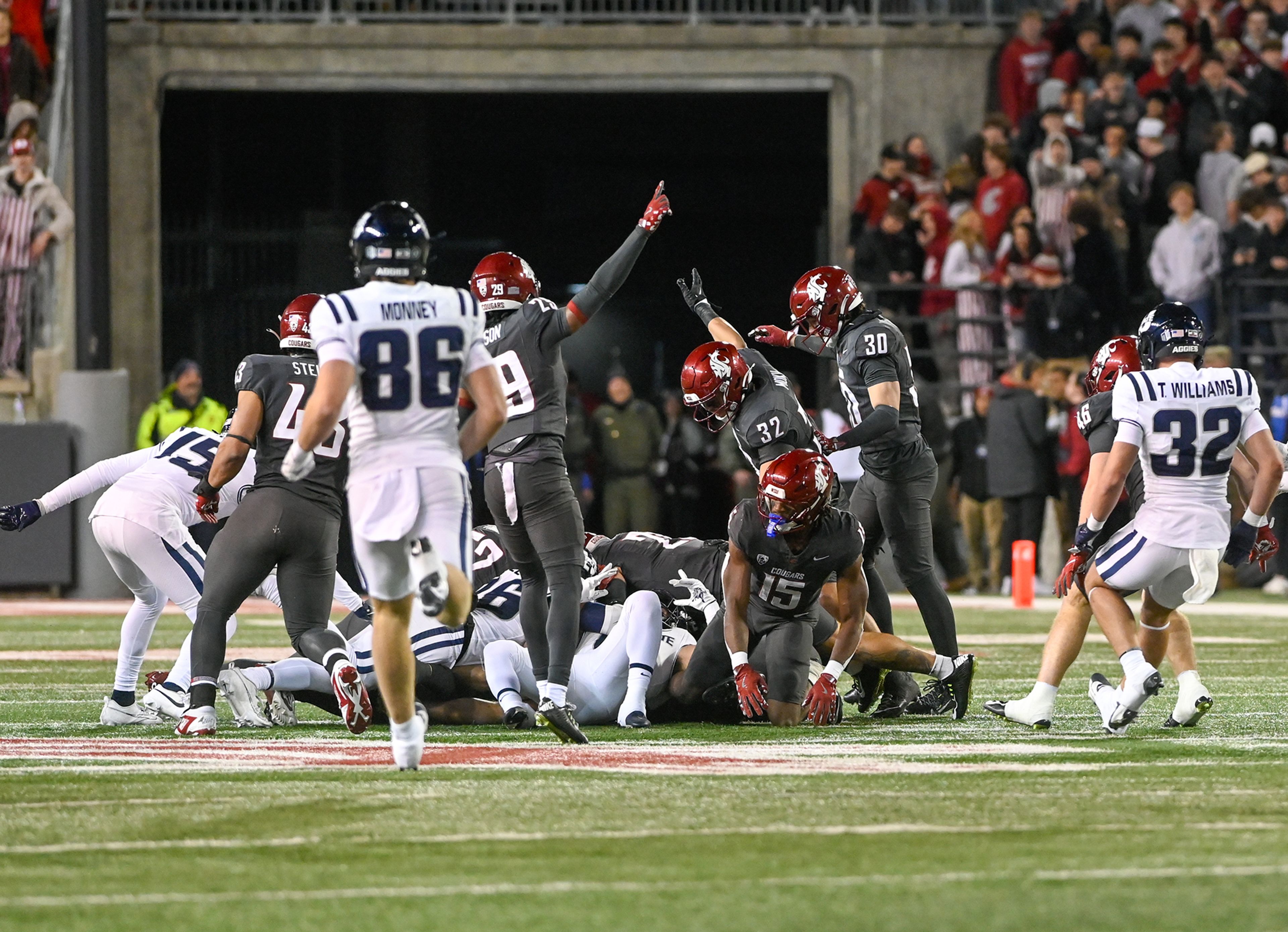 Washington State players motion for Cougar control of a kickoff Saturday at Gesa Field in Pullman. The ball was awarded to Utah State after a review of the play.