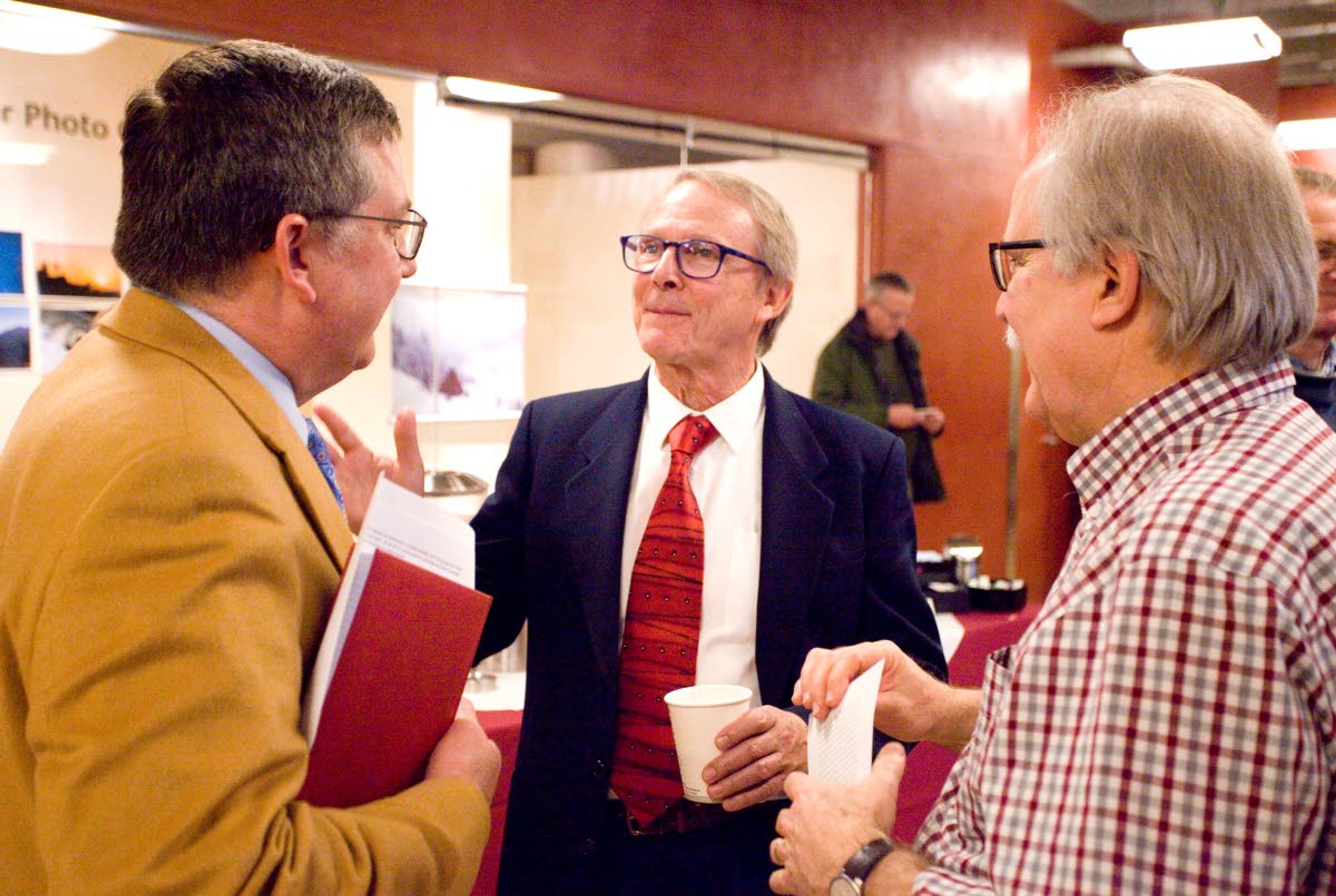 In this 2017 file photo, Washington State University Regents Distinguished Alumnus James Wells, center, talks with WSU President Kirk Schulz, left, and College of Veterinary Medicine Dean Bryan Slinker.