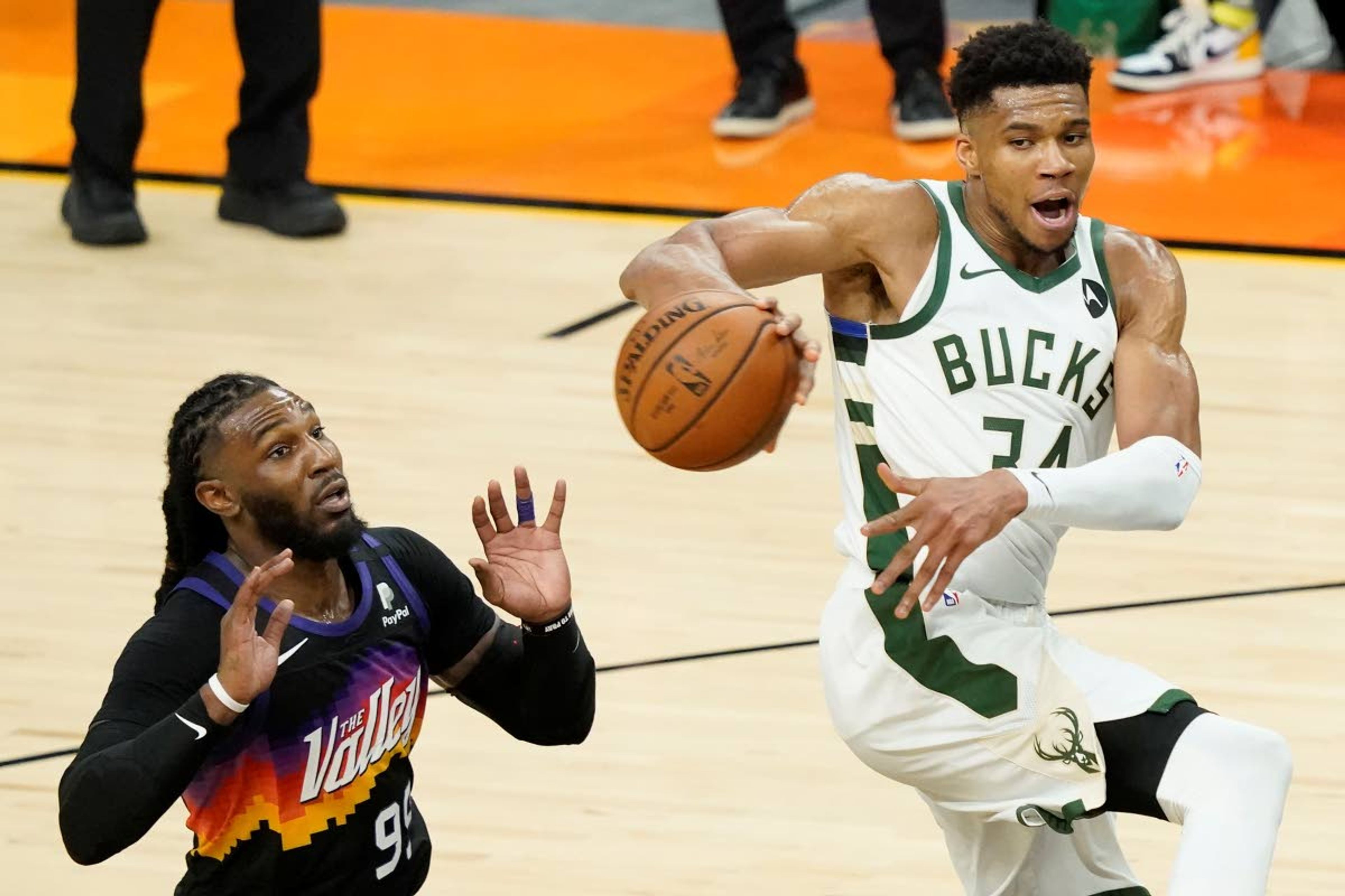 Milwaukee Bucks forward Giannis Antetokounmpo, right, passes the ball against Phoenix Suns forward Jae Crowder during the second half of Game 2 of basketball's NBA Finals, Thursday, July 8, 2021, in Phoenix. (AP Photo/Matt York)