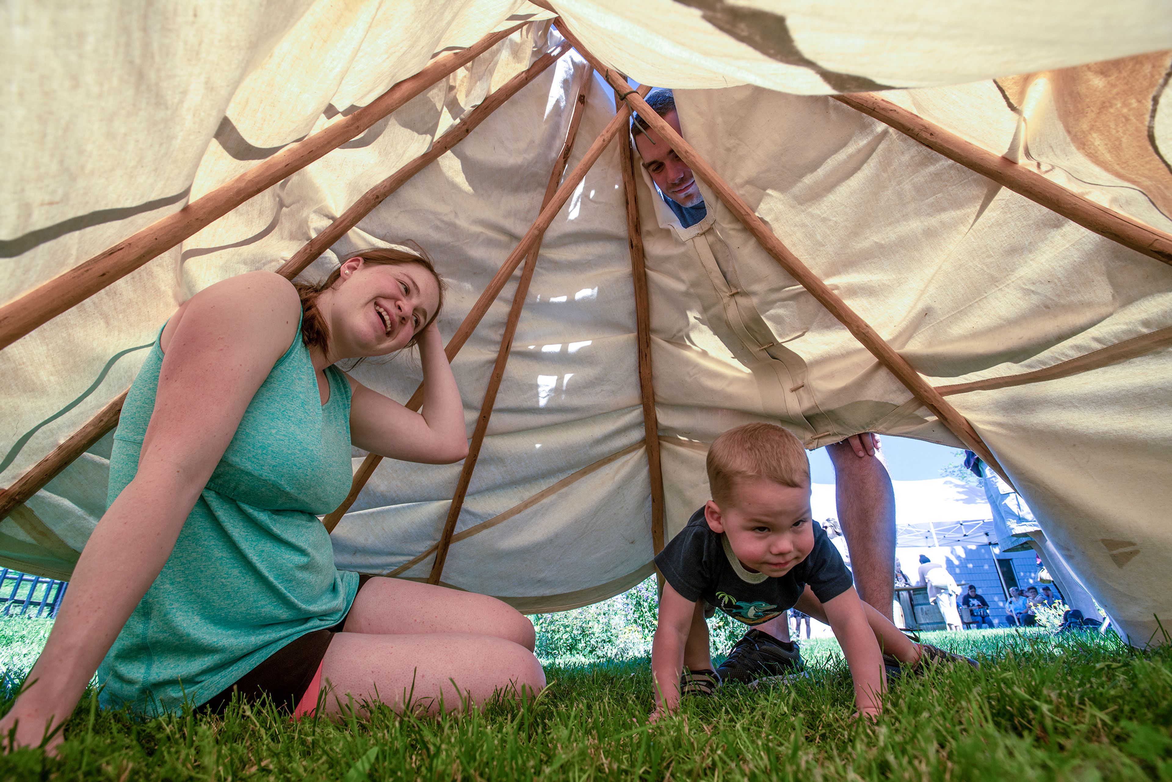 Zach Wilkinson/Daily News Zach Krause, 2, crawls into a tepee with his mother, Ruth, while his father, Josh, peeks in from above.