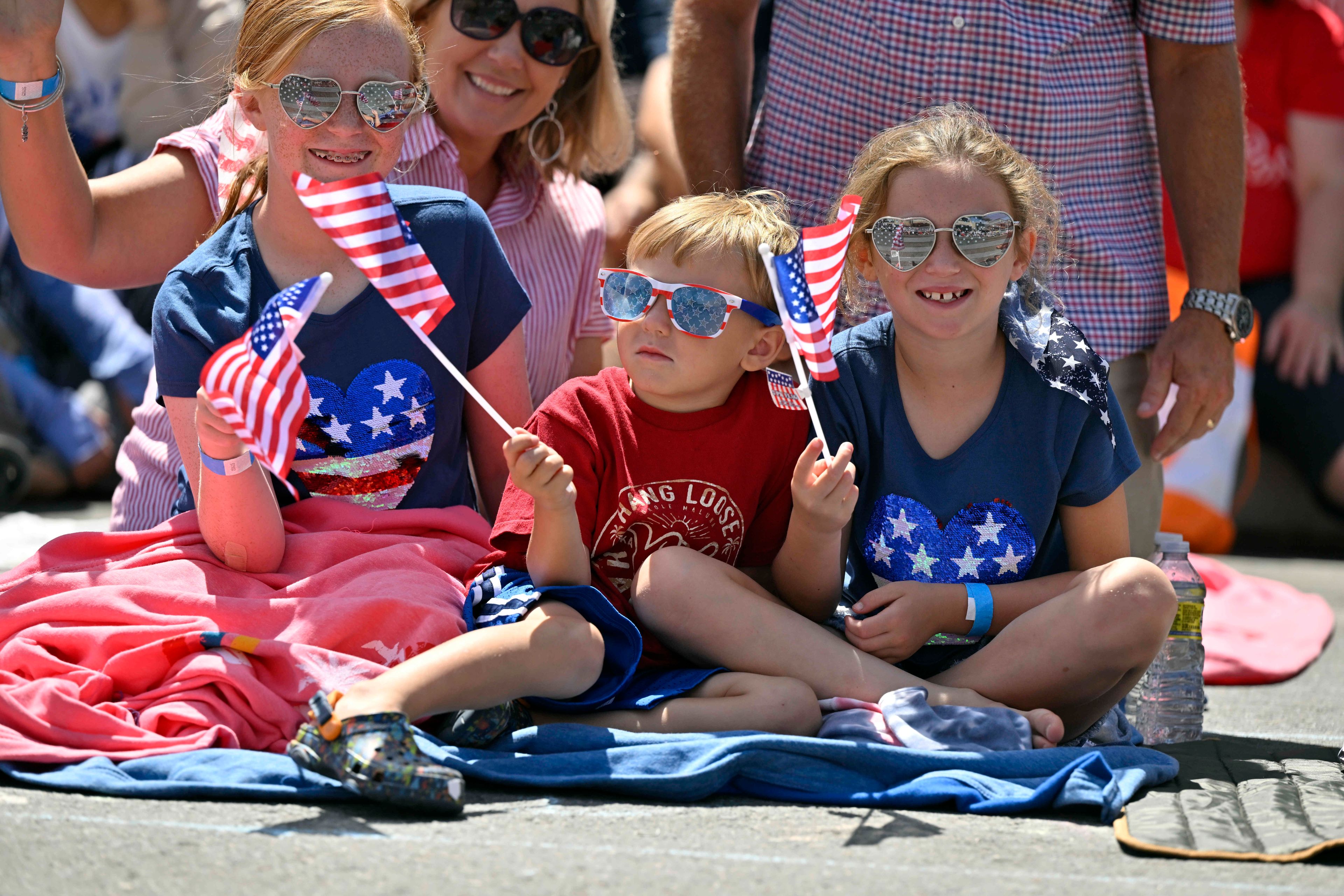 Lesley McMillan, along with her kids, Johnelle, left, Hayden and Jolynn watch the 118th Huntington Beach 4th of July Parade on Main Street in Huntington Beach, Calif., on Monday, July 4, 2022. (Jeff Gritchen/The Orange County Register via AP)