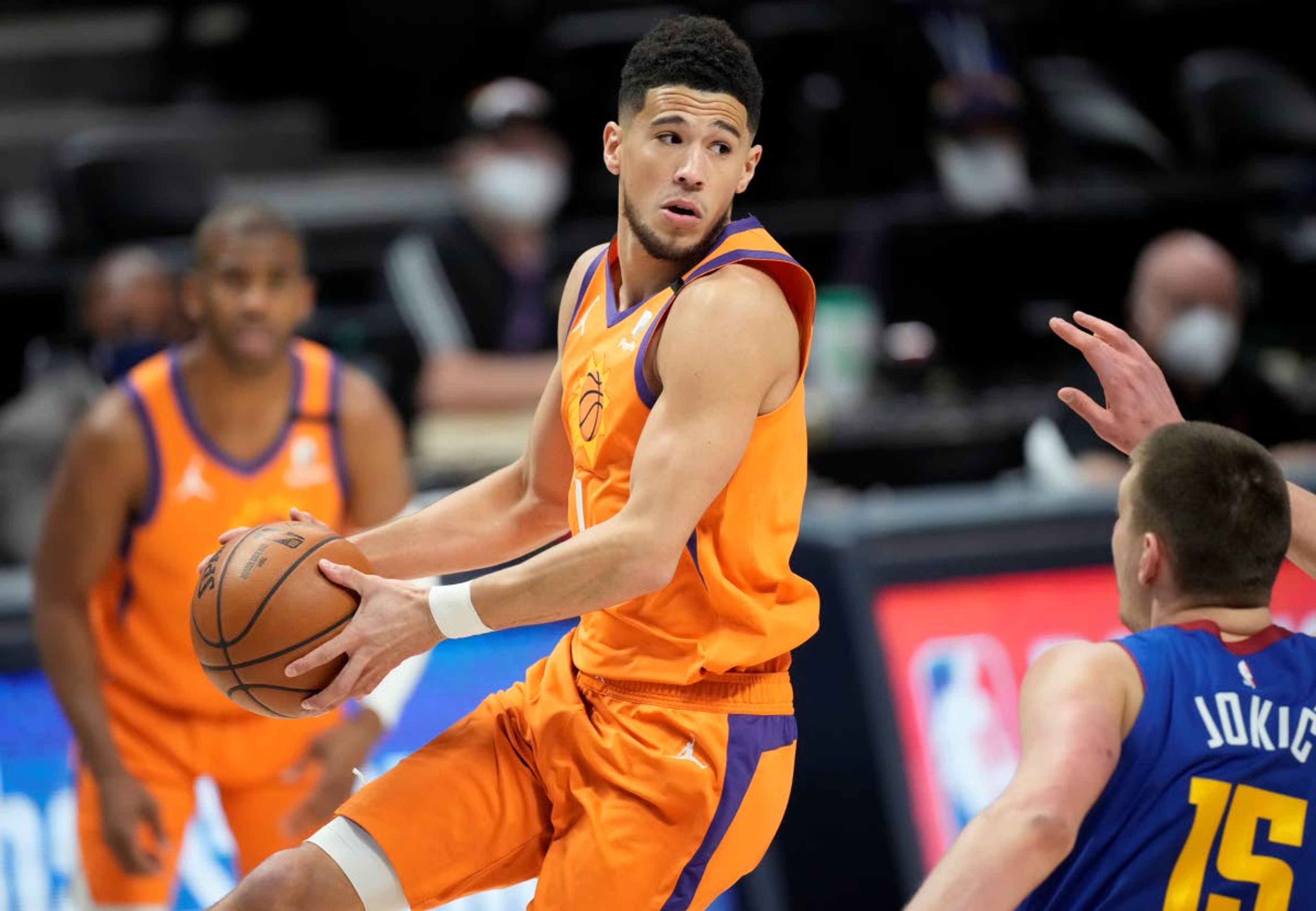 Associated PressSuns guard Devin Booker looks to pass the ball as Nuggets center Nikola Jokic defends in the first half of Game 3 of an NBA second-round playoff series Friday in Denver.