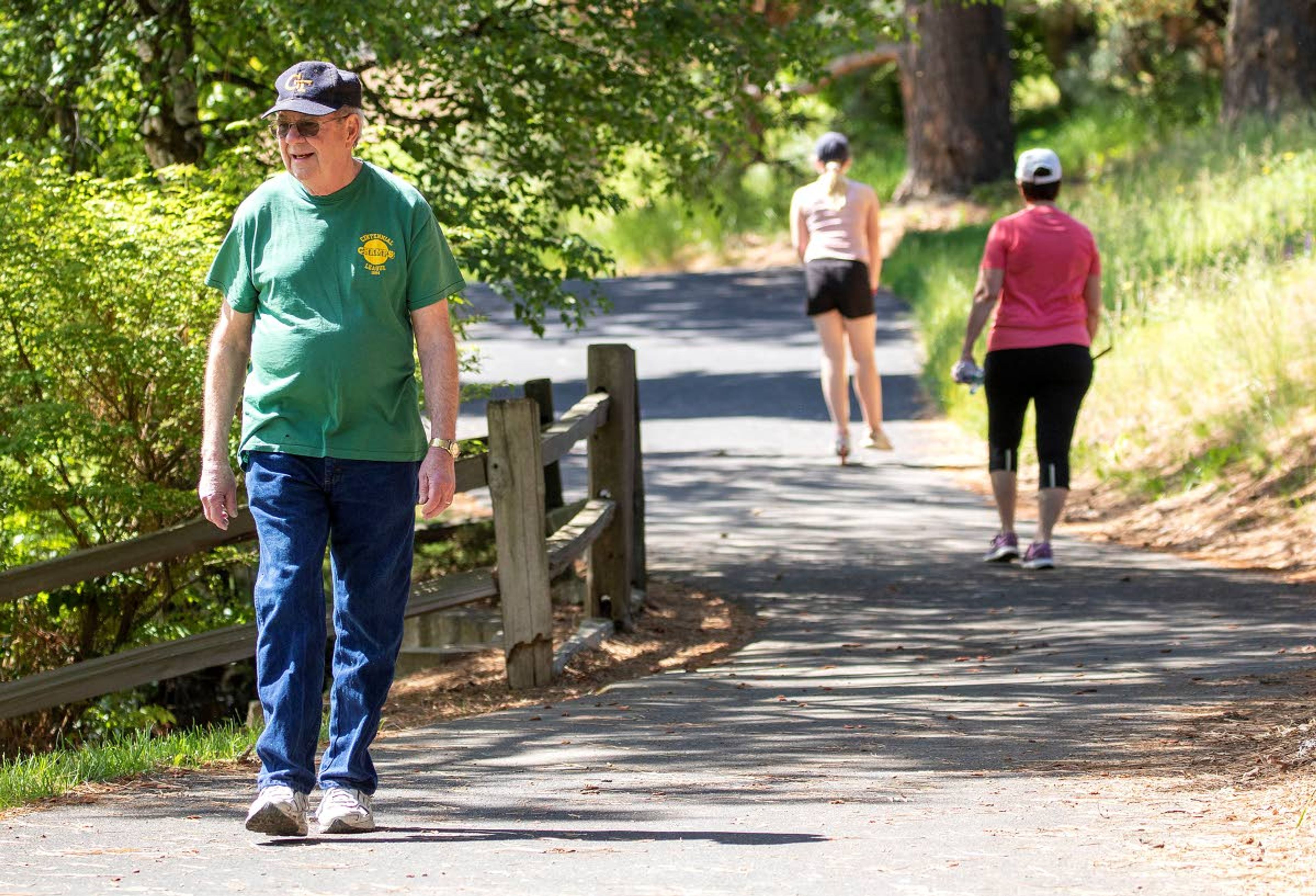 Dave Hutton and other residents walk on a path Thursday at Sunnyside Park in Pullman. Researches at Washington State University found that living in a pedestrian-friendly area with a mixed-age population results in a higher likelihood of living to age 100.