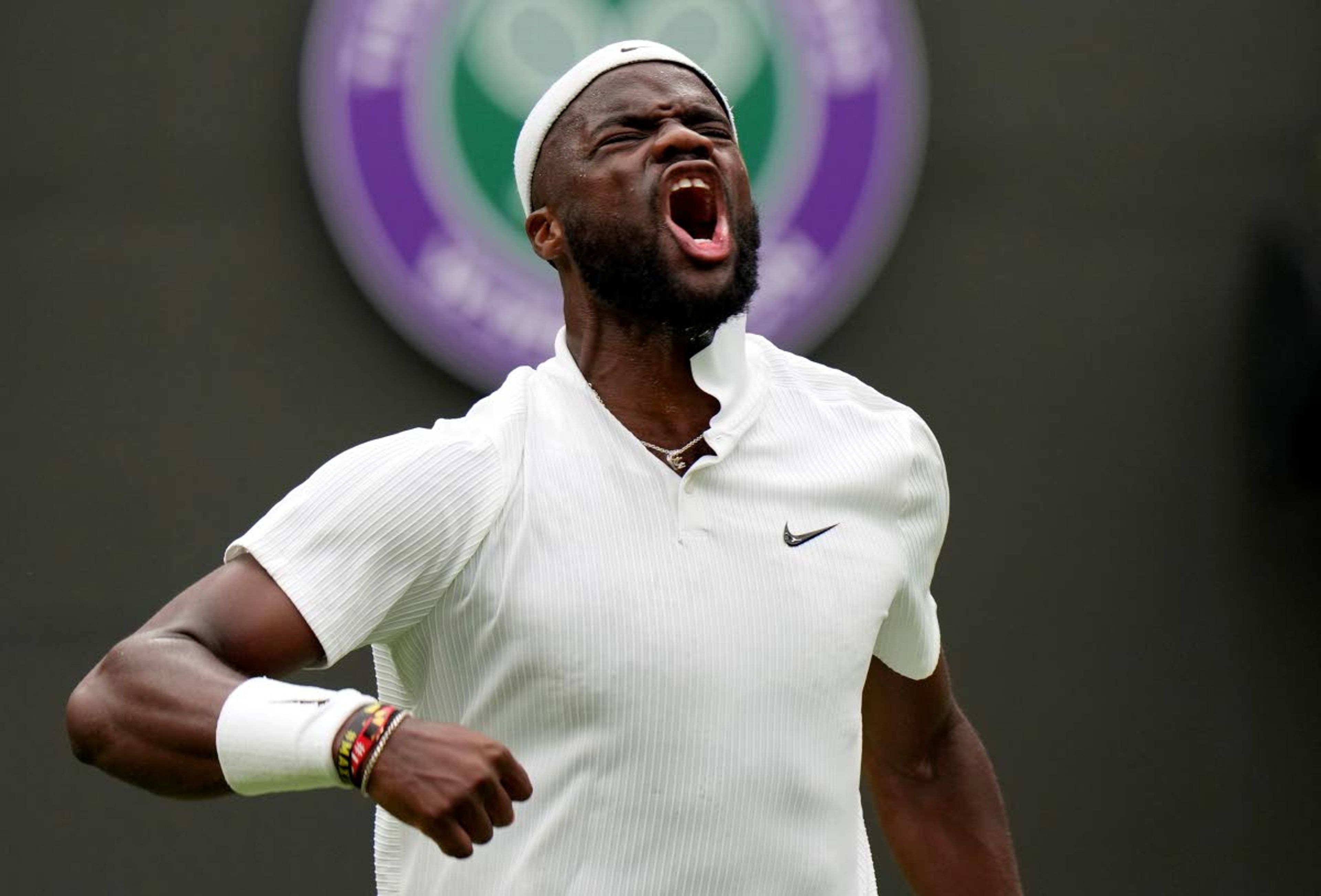 Frances Tiafoe of the US celebrates after breaking the serve of Stefanos Tsitsipas of Greece during the men's singles match on day one of the Wimbledon Tennis Championships in London, Monday June 28, 2021. (AP Photo/Alastair Grant)