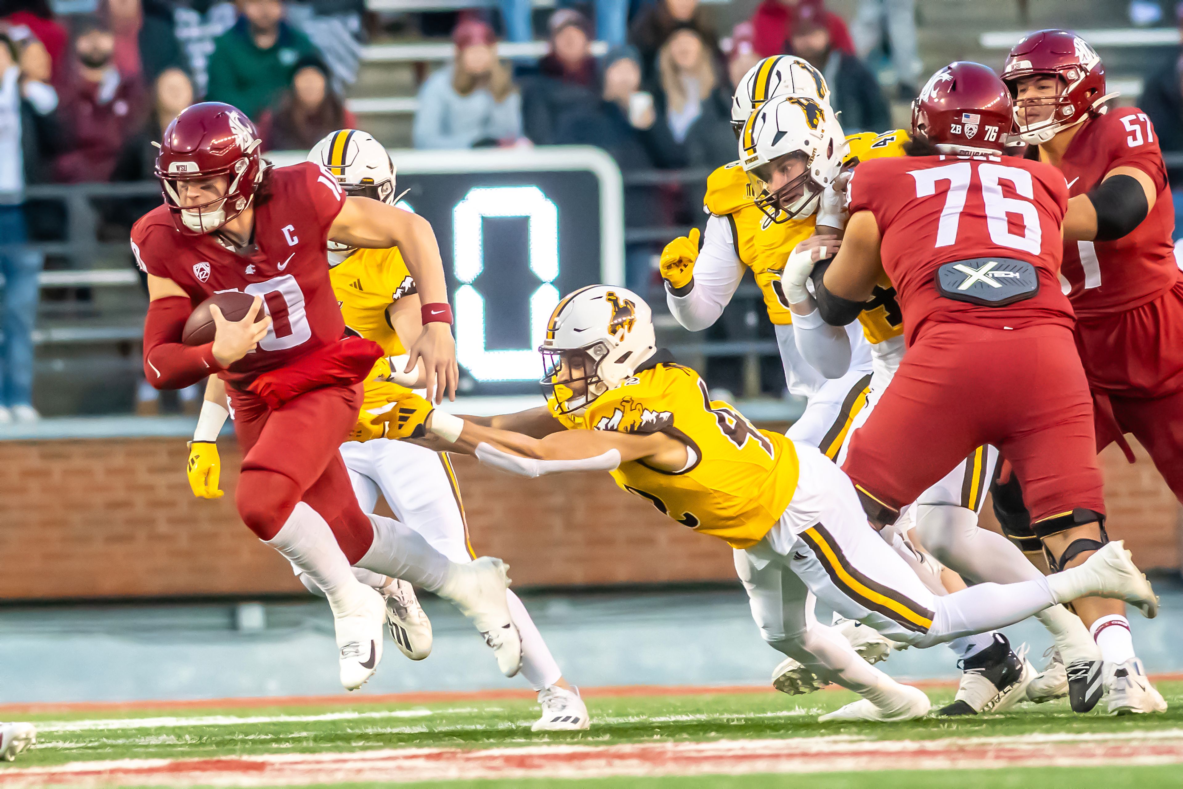 Washington State quarterback John Mateer runs the ball as Wyoming safety Isaac White leaps after him during a quarter of a college football game on Saturday, at Gesa Field in Pullman.