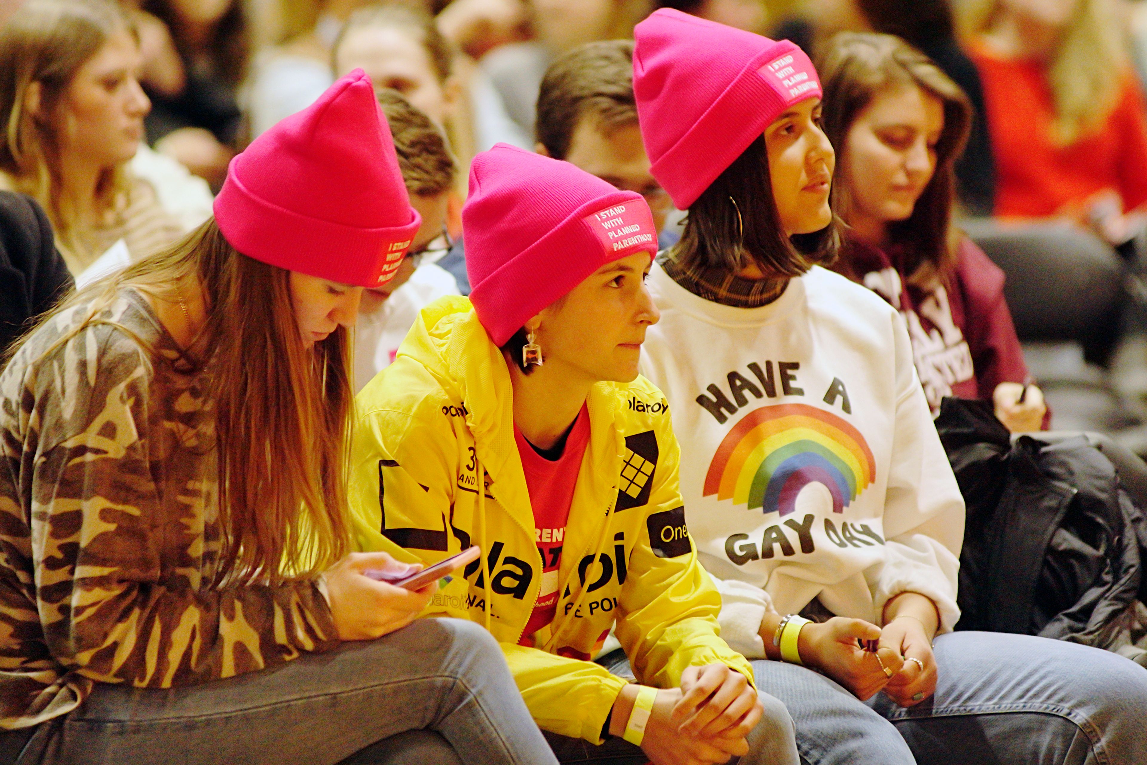 Protesters Aspynn Owsle left, Marguerite Watts, center, and Katelyn Hettinga wait for the start of a talk by the Rev. Doug Wilson on Tuesday in the Pitman Center at UI.