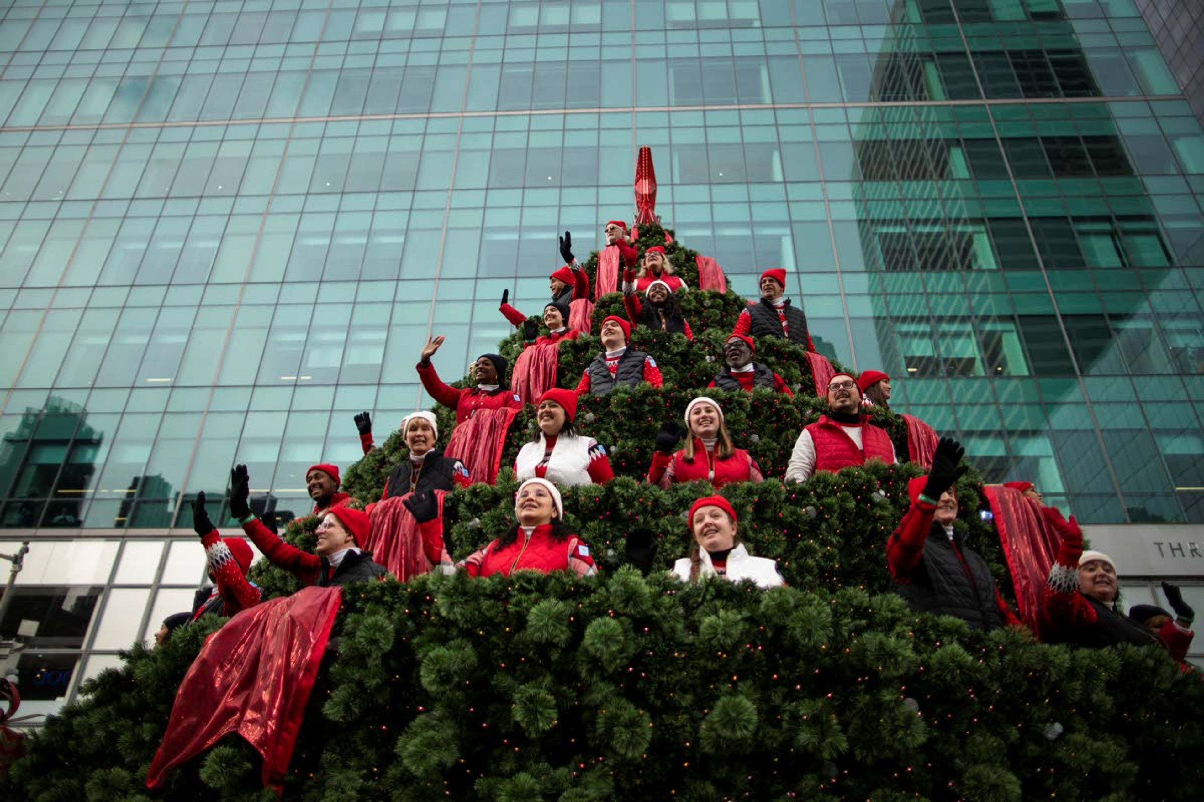 Carolers wave at spectators as they ride down Sixth Avenue in the Macy's Singing Christmas Tree float during the Macy's Thanksgiving Day Parade, Thursday, Nov. 25, 2021, in New York. (AP Photo/Eduardo Munoz Alvarez)