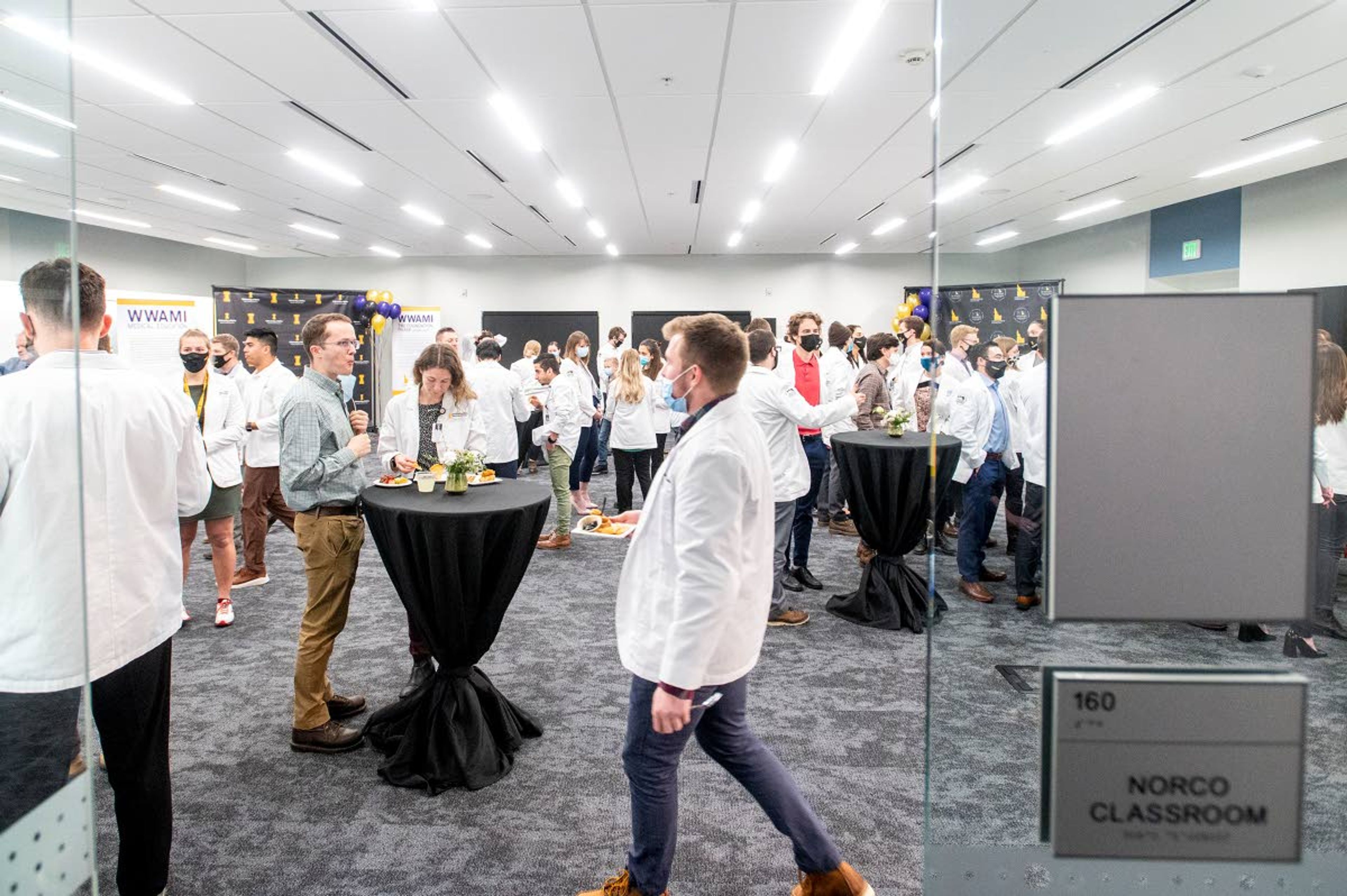 Medical students and University of Idaho staff dish plates of food and mingle in the new Norco classroom at the WWAMI Medical Education Building in Moscow on Monday night.