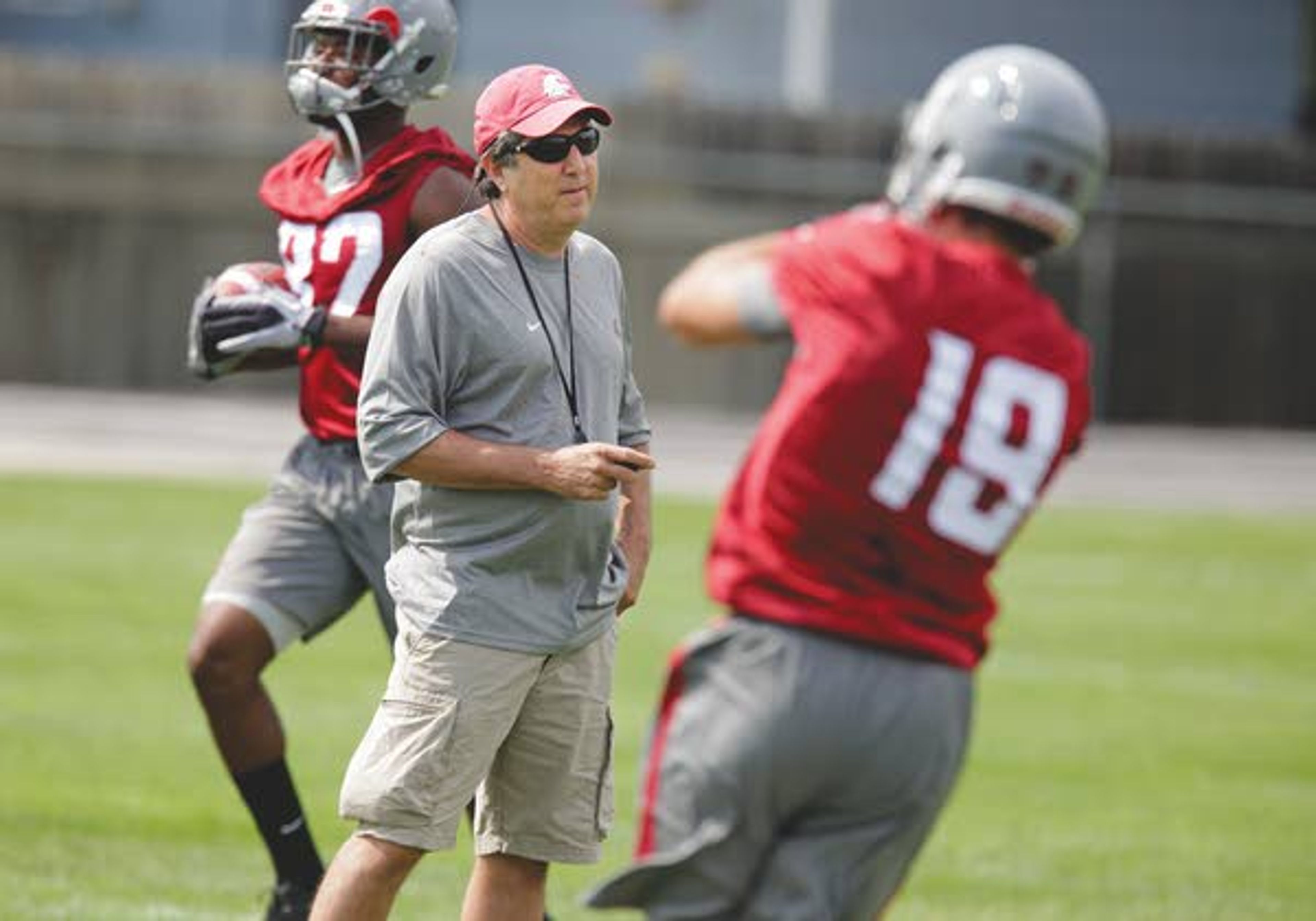 Washington State coach Mike Leach, center, watches wide receivers Brett Bartolone (19) and Bobby Ratliff, left, run drills during the opening practice of fall camp Friday at Sacajawea Junior High School in Lewiston.