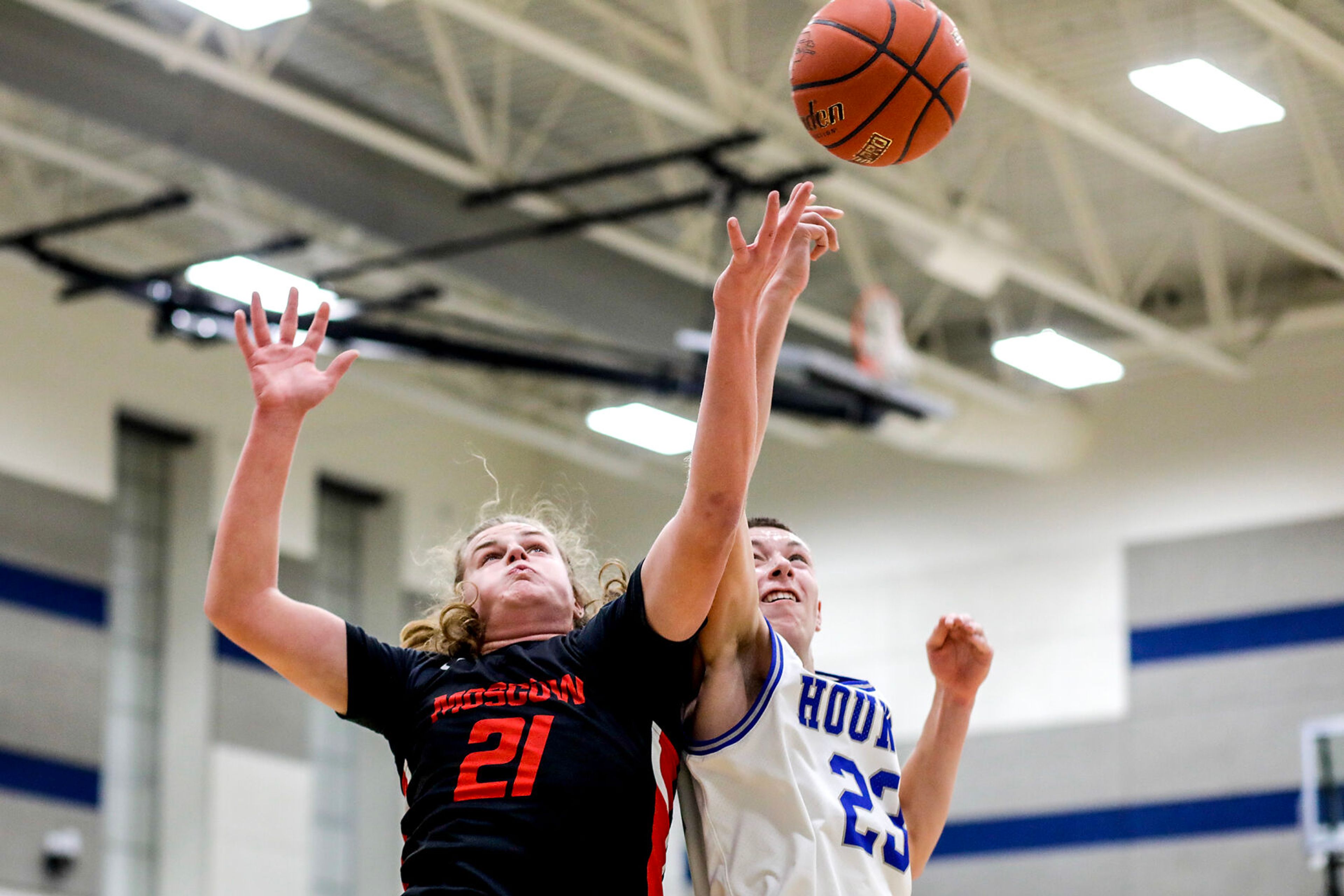 The ball bounces off the fingers of Moscow post Joey Williams, left, and Pullman small forward Dane Sykes as they go after a rebound during Saturday's nonleague boys basketball game.