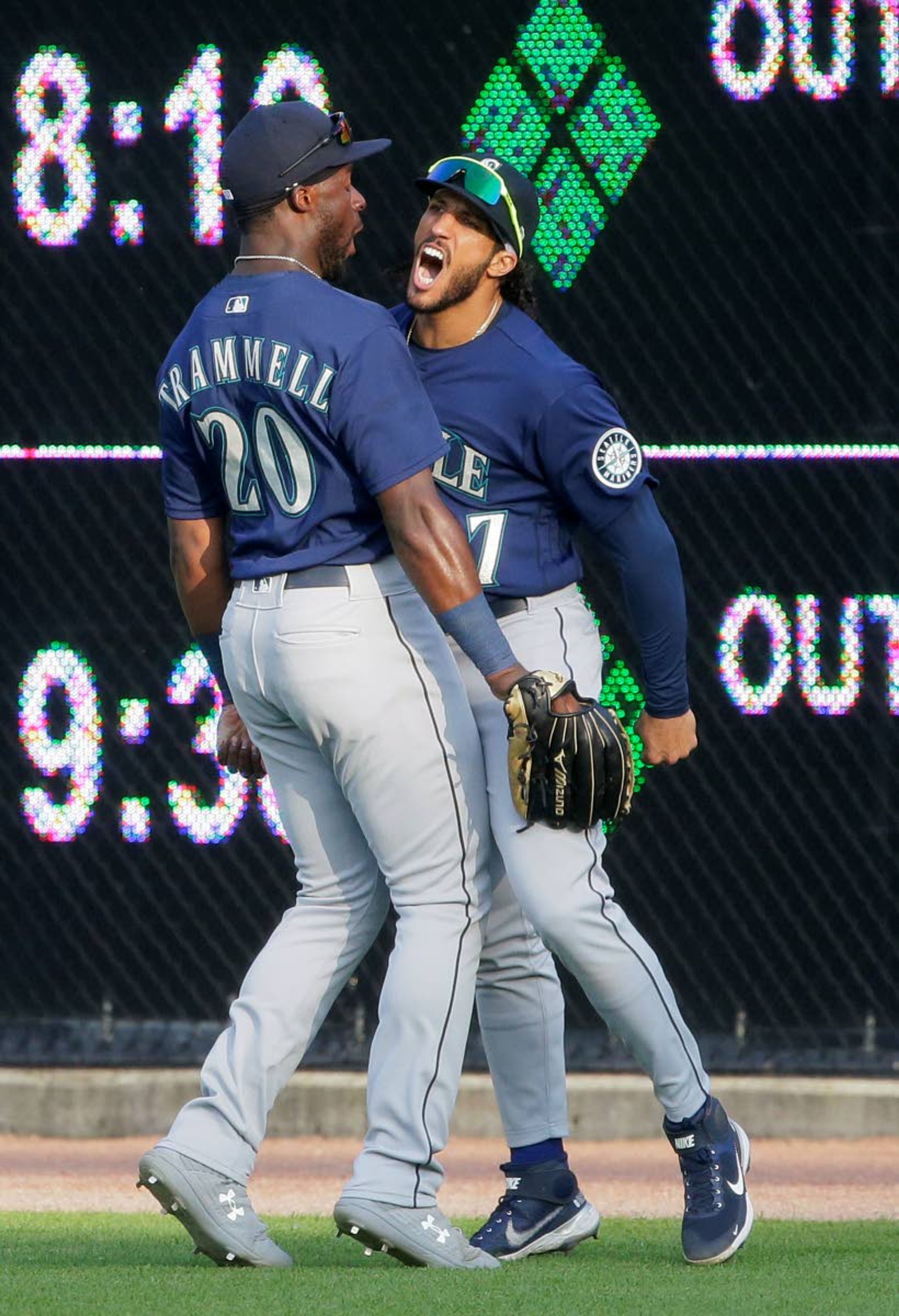 Seattle Mariners right fielder Dillon Thomas (27) celebrates with center fielder Taylor Trammell (20) after going up against the scoreboard to catch a fly ball hit by Detroit Tigers' Niko Goodrum during the second inning of a baseball game Wednesday, June 9, 2021, in Detroit. (AP Photo/Duane Burleson)