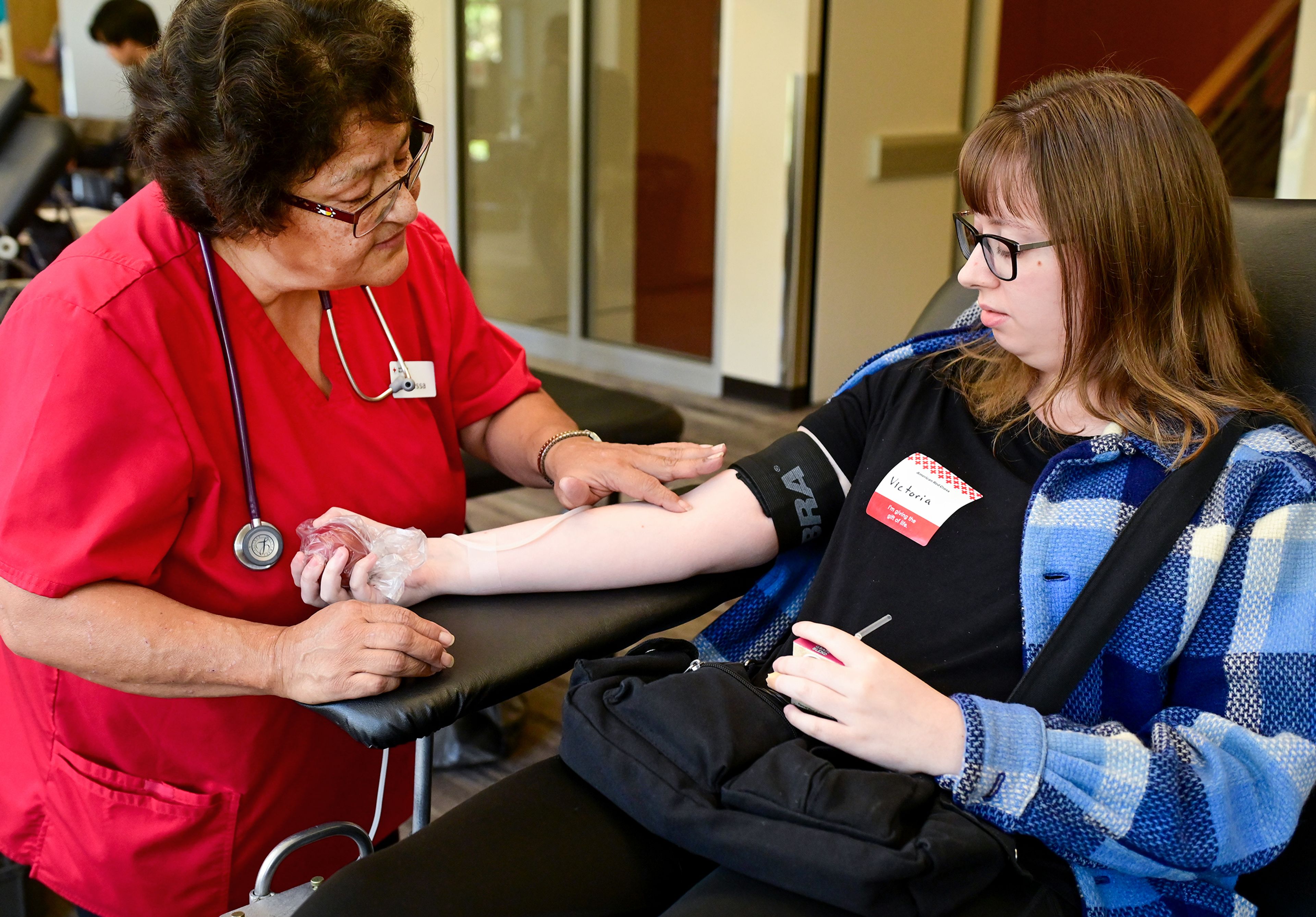 Vanessa Henry, a collections specialist with American Red Cross, prepares University of Idaho junior Victoria Keem for a blood donation Wednesday on campus in Moscow. Keem is just two donations away from reaching the milestone of a gallon of blood donated.