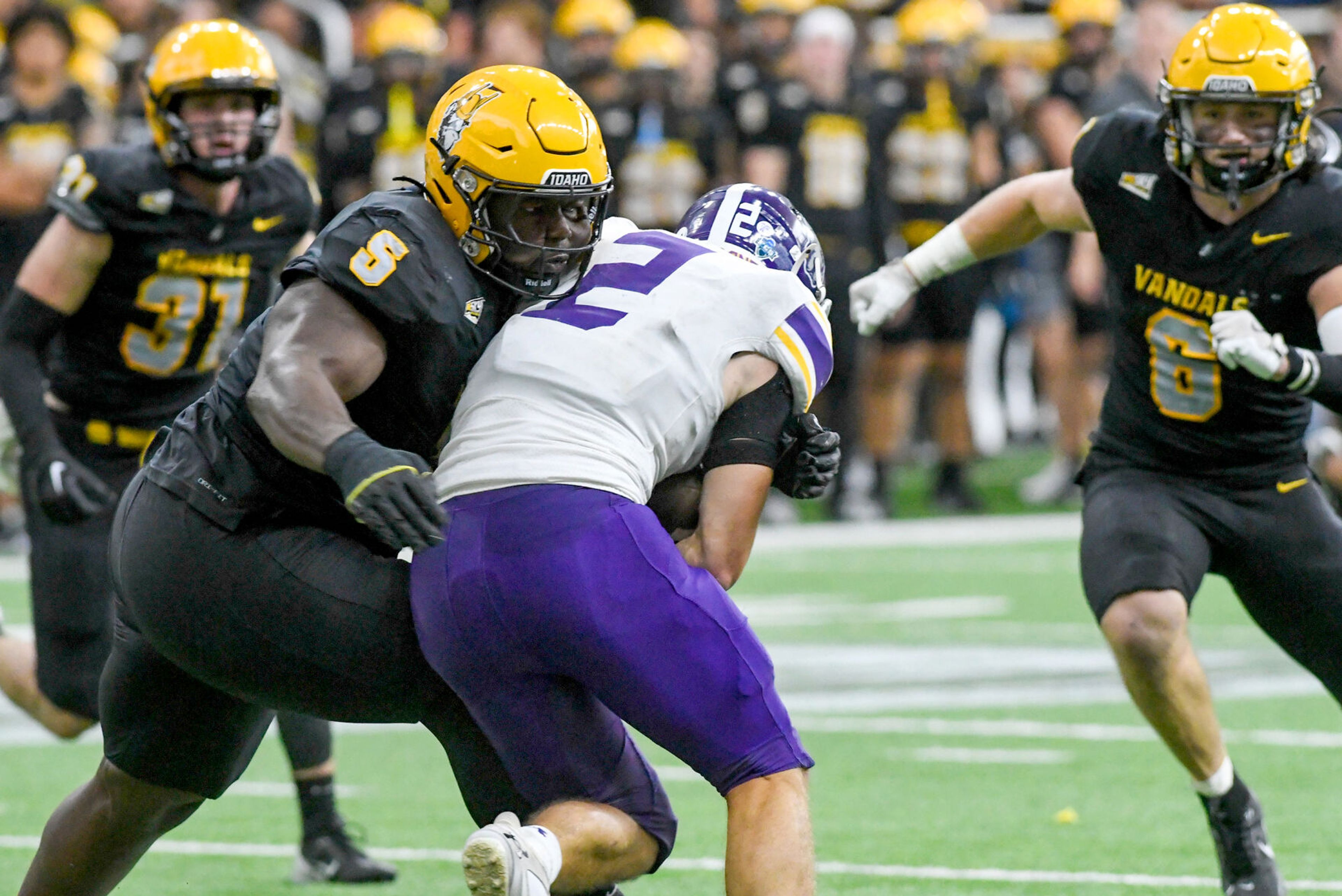 Idaho Vandals defensive lineman Jahkari Larmond (5) tackles Albany Great Danes running back Griffin Woodell (2) Saturday at the P1FCU Kibbie Dome in Moscow.