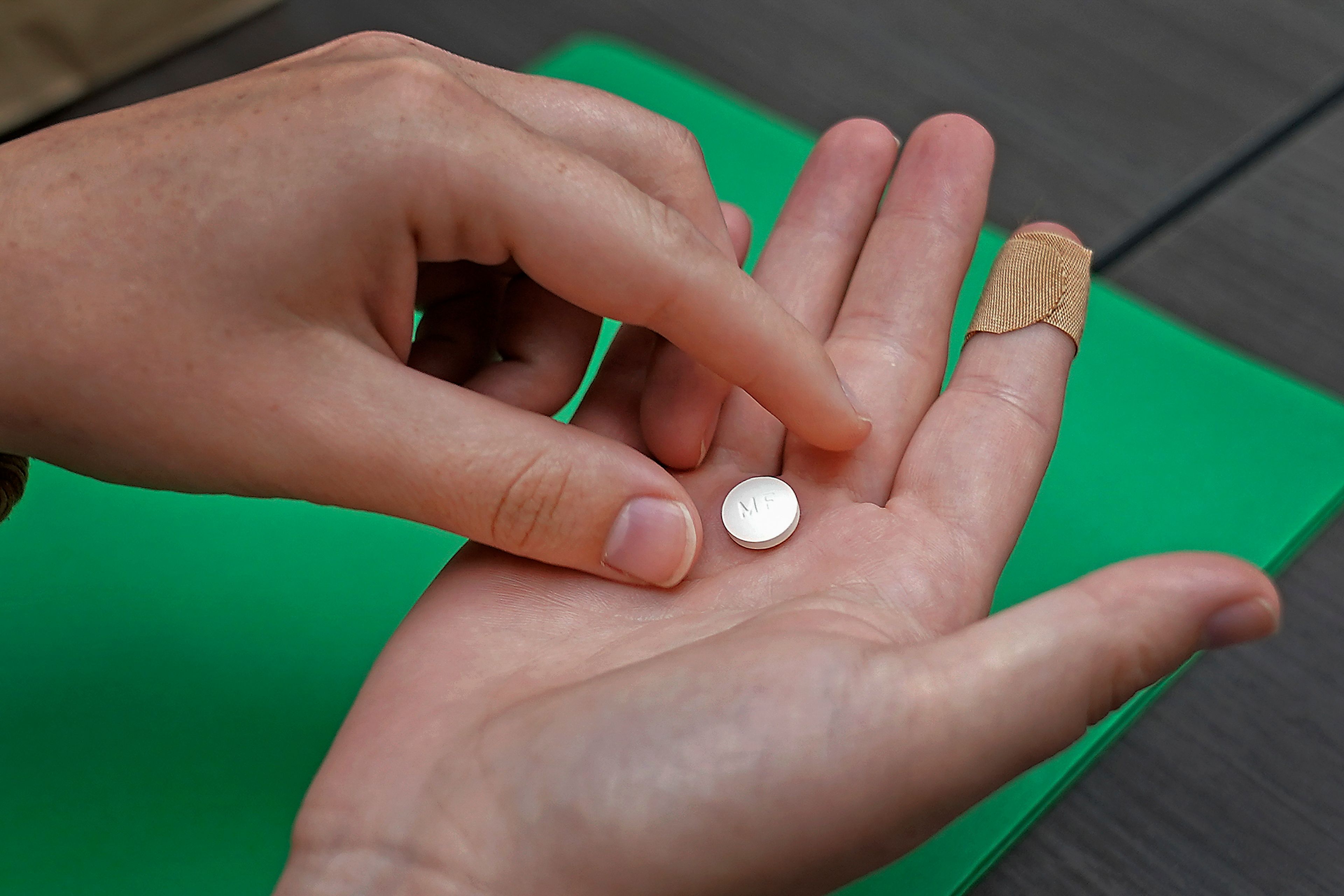 FILE - A patient prepares to take the first of two combination pills, mifepristone, for a medication abortion during a visit to a clinic in Kansas City, Kan., on Wednesday, Oct. 12, 2022. The Supreme Court is facing a self-imposed Friday, April 21, 2023, night deadline to decide whether women’s access to a widely used abortion pill will stay unchanged until a legal challenge to its Food and Drug Administration approval is resolved. The justices are weighing arguments that allowing restrictions contained in lower-court rulings to take effect would severely disrupt the availability of the drug, mifepristone, which is used in the most common abortion method in the United States. (AP Photo/Charlie Riedel, File)