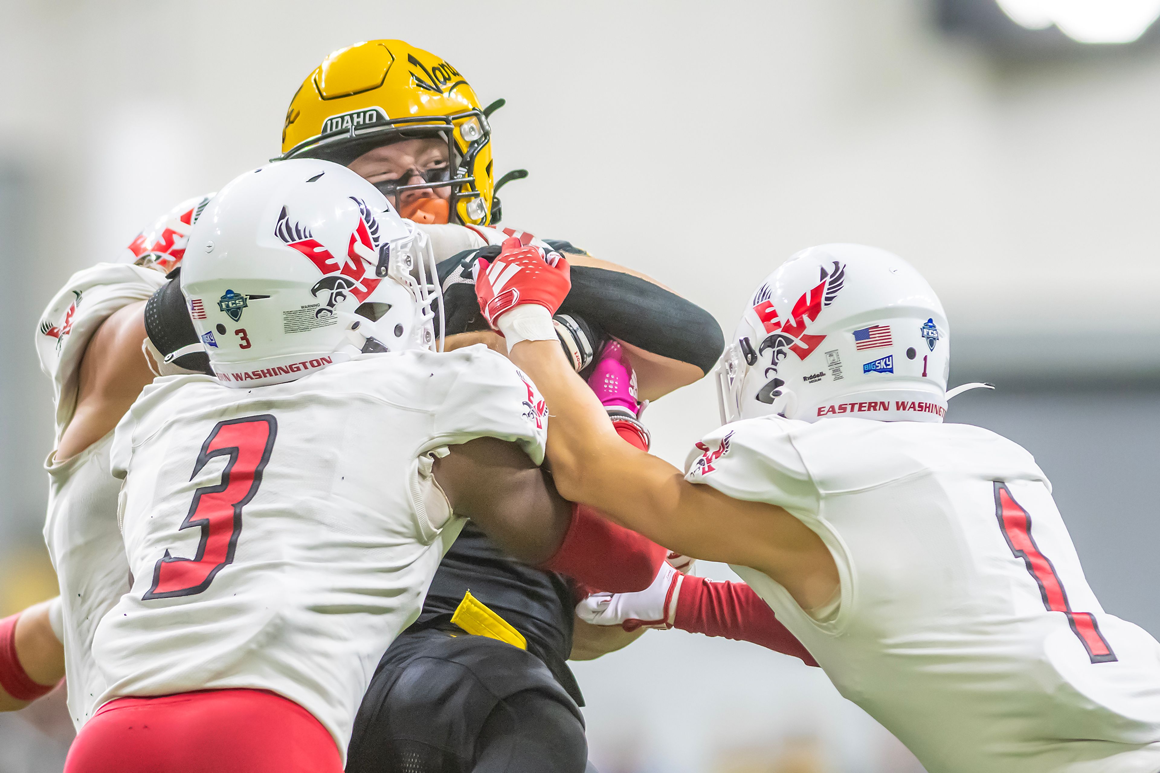 Idaho running back Art Williams is tackled by Eastern Washington cornerback DaJean Wells and Eastern Washington cornerback Cage Schenck  during a Big Sky game Saturday at the Kibbie Dome in Moscow. ,